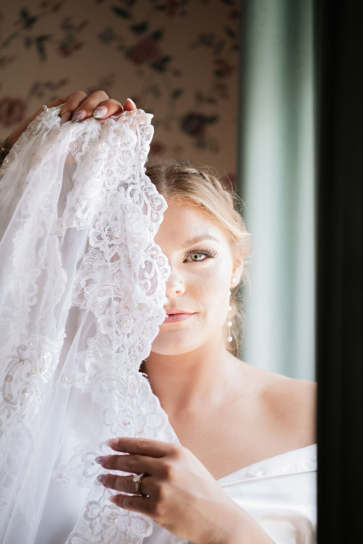 Close-up view of delicate white lace wedding veil details.