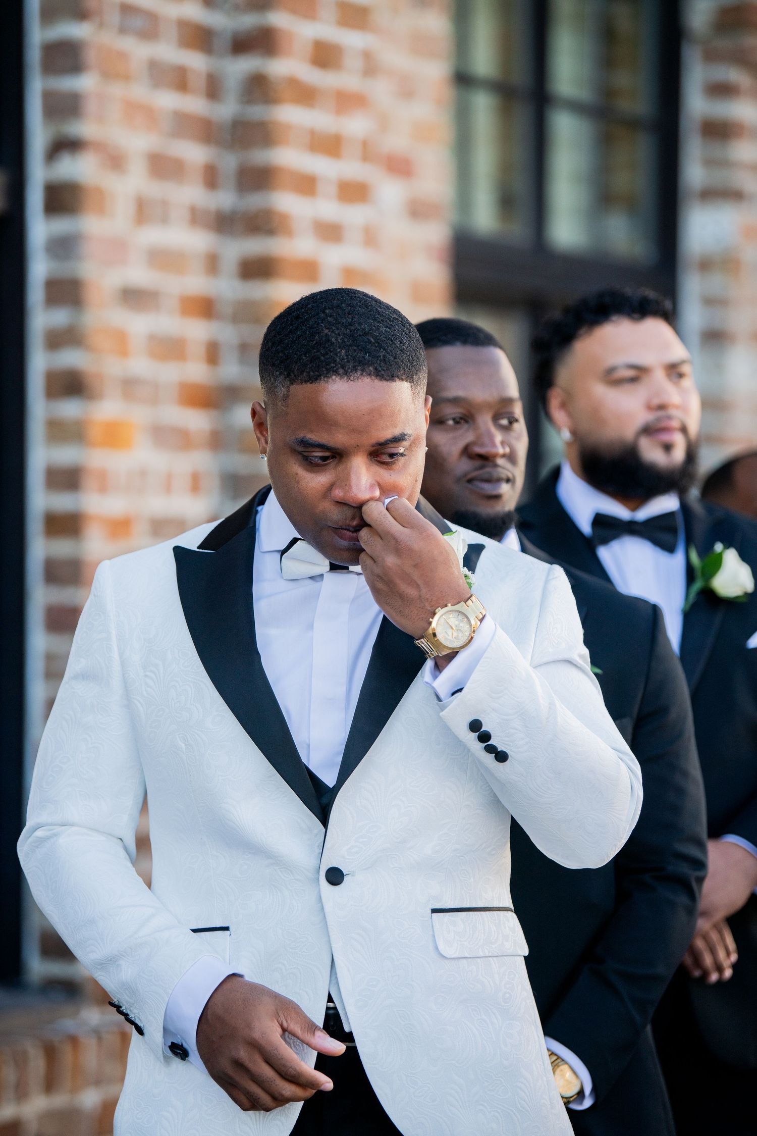 An emotional moment captured as groomsmen stand together before the ceremony.