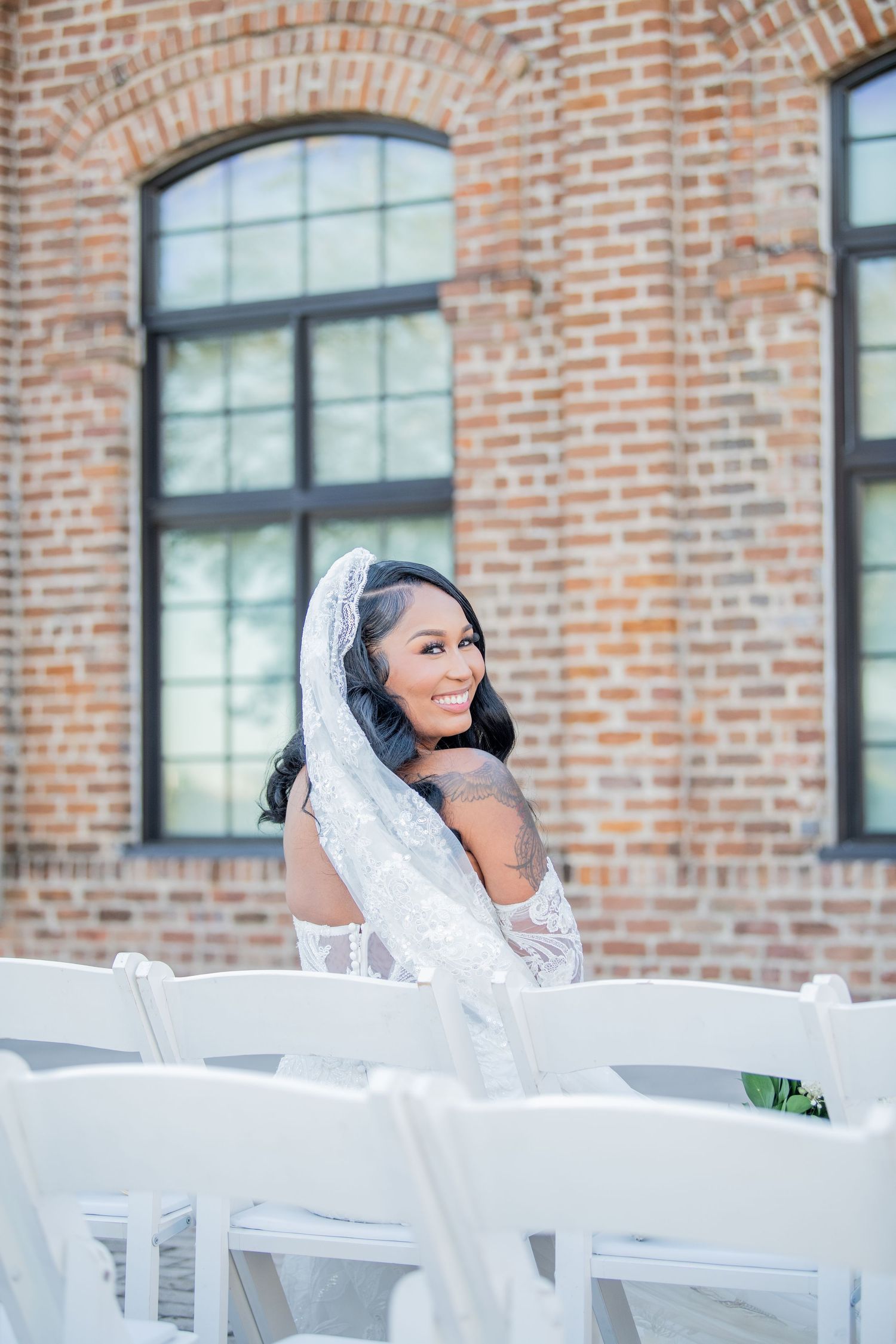 Wedding celebration setup with white chairs and exposed brick wall creating an industrial chic atmosphere.