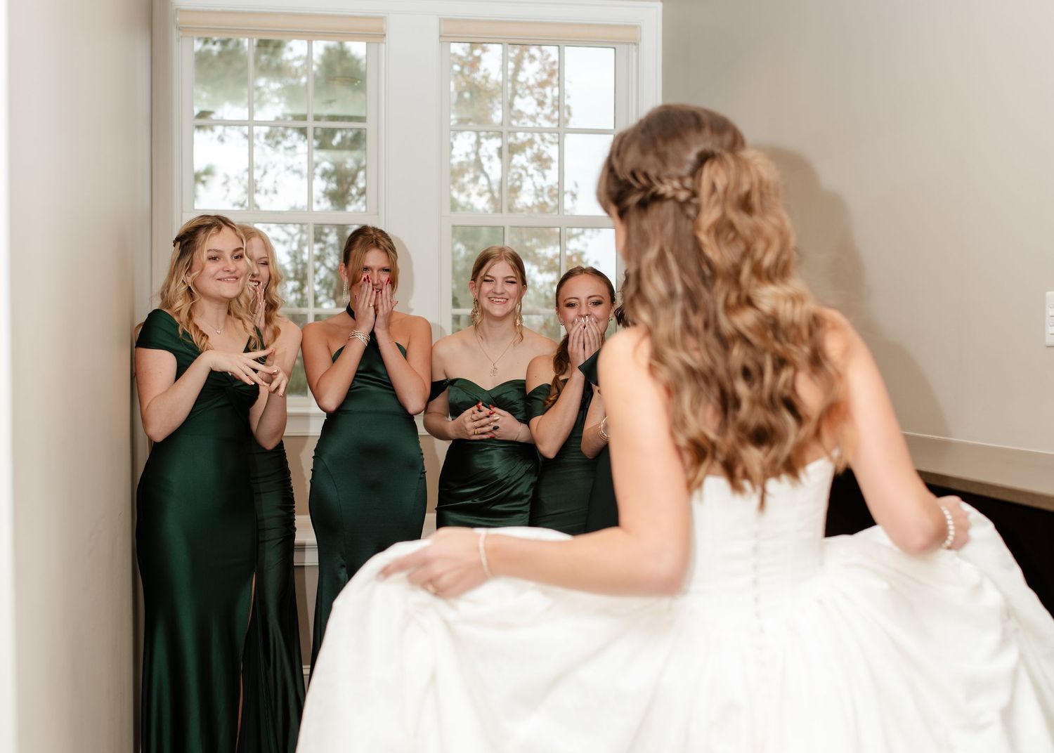 A fun photo series showing bridesmaids in dark dresses posing with the bride in white.