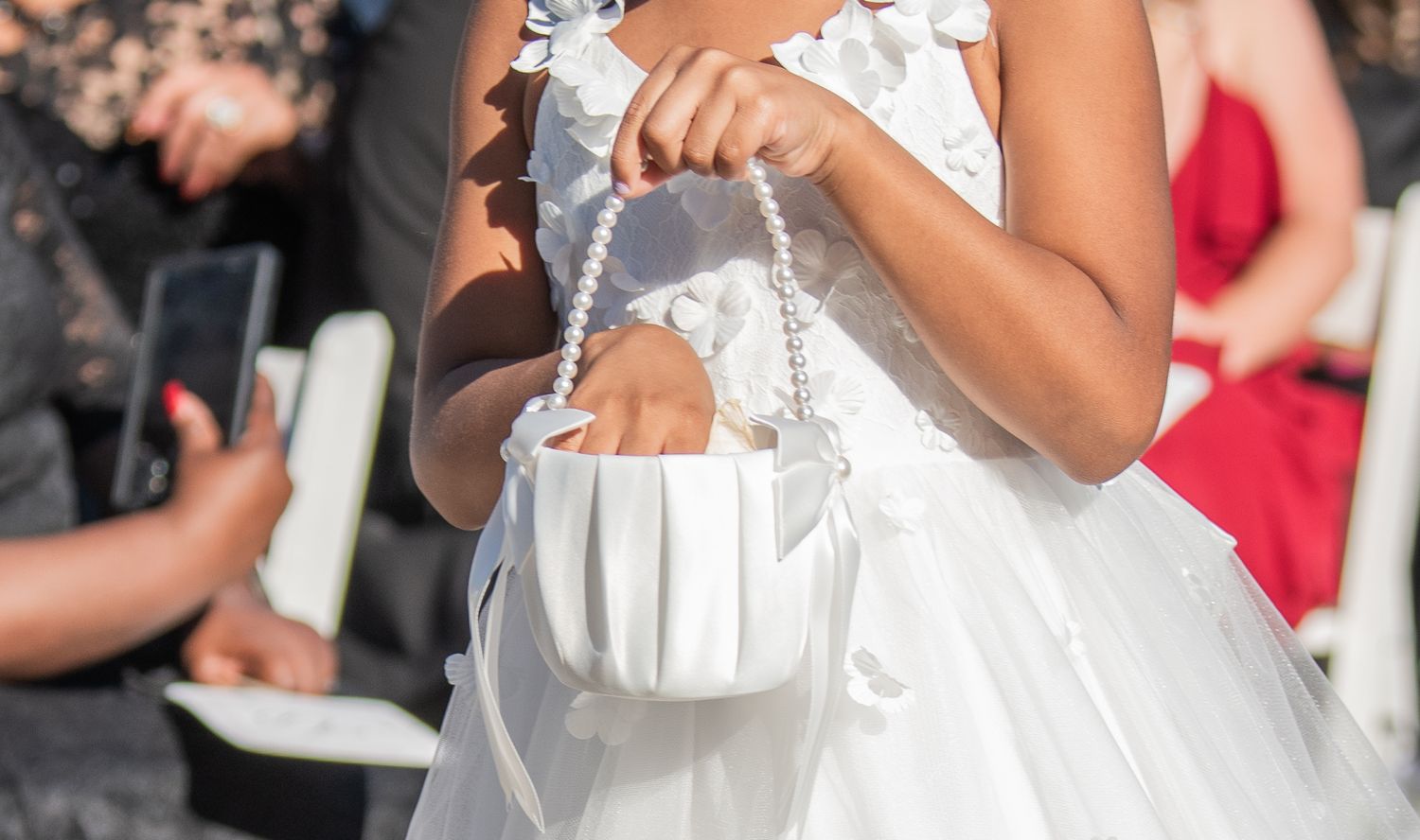 Close-up detail of white wedding dress fabric and decorative elements.
