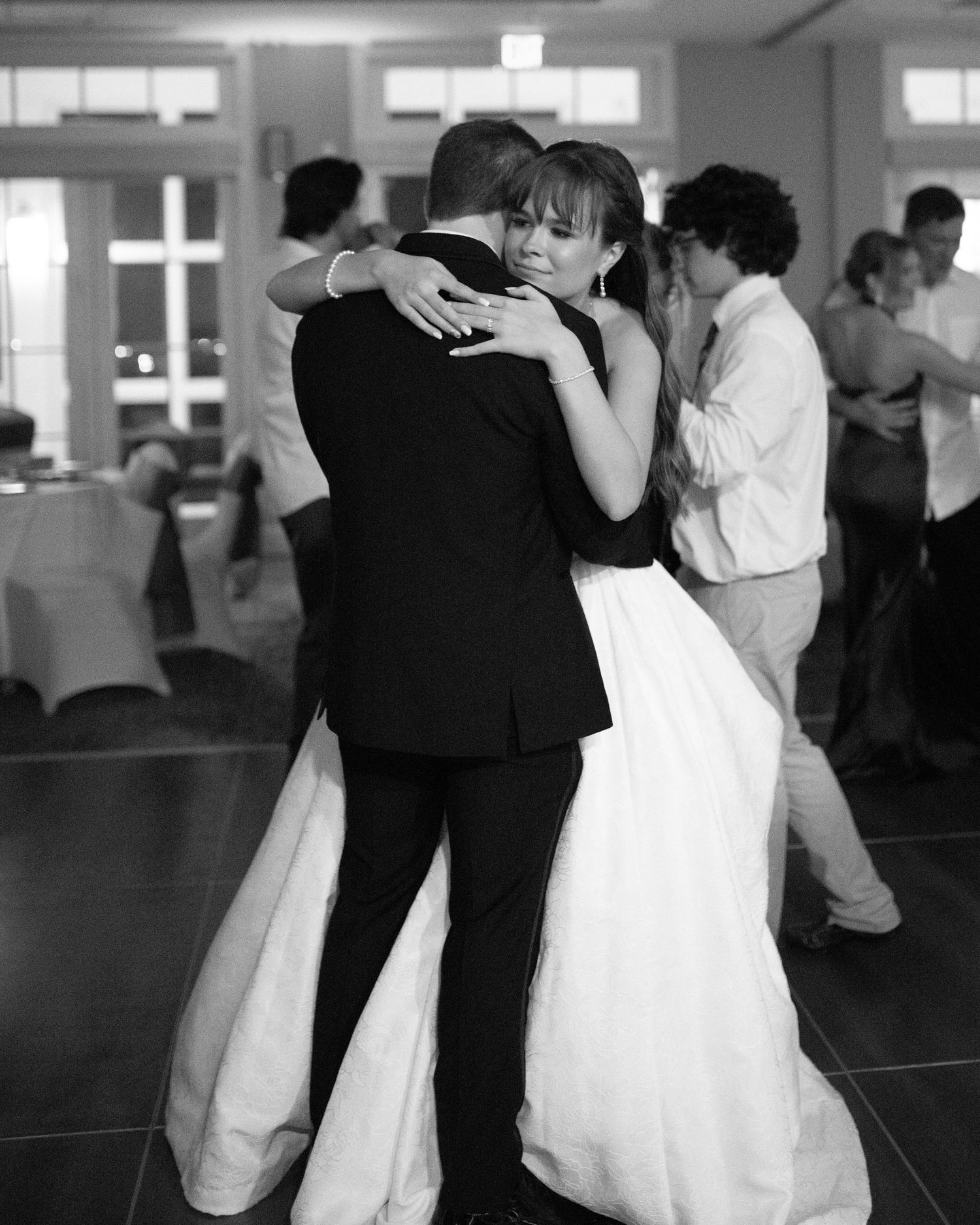 Black and white photo of couples dancing together at a wedding celebration.