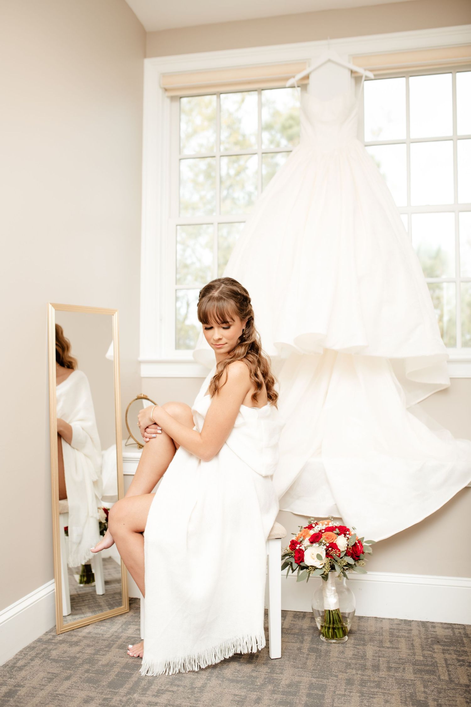 Wedding preparation scene with white dress hanging and bridal accessories.