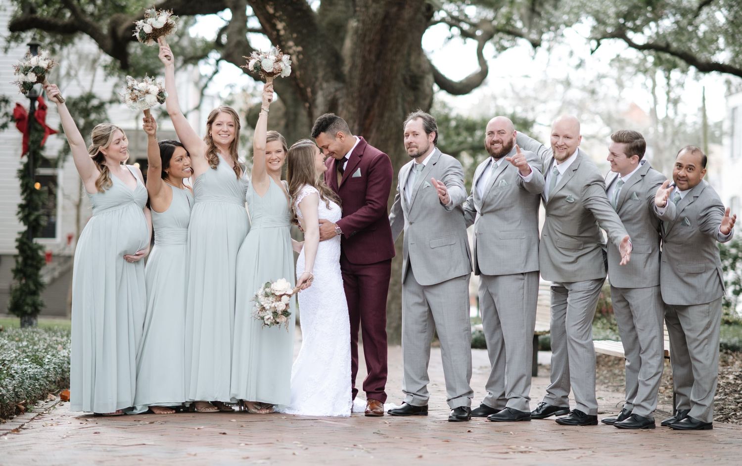 Wedding party poses under a majestic oak tree with Spanish moss.