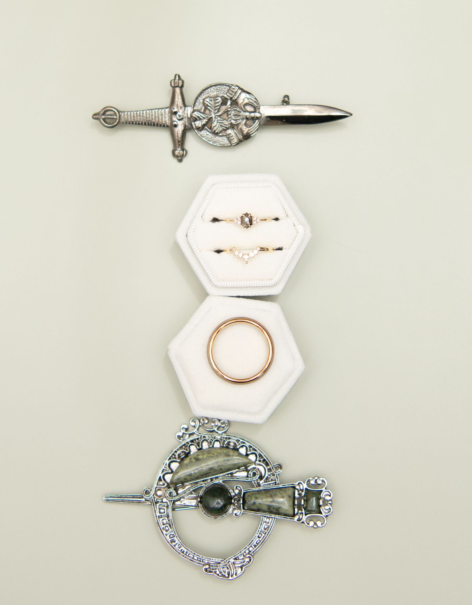 Vintage-style brooches and jewelry pieces arranged on white hexagonal displays.