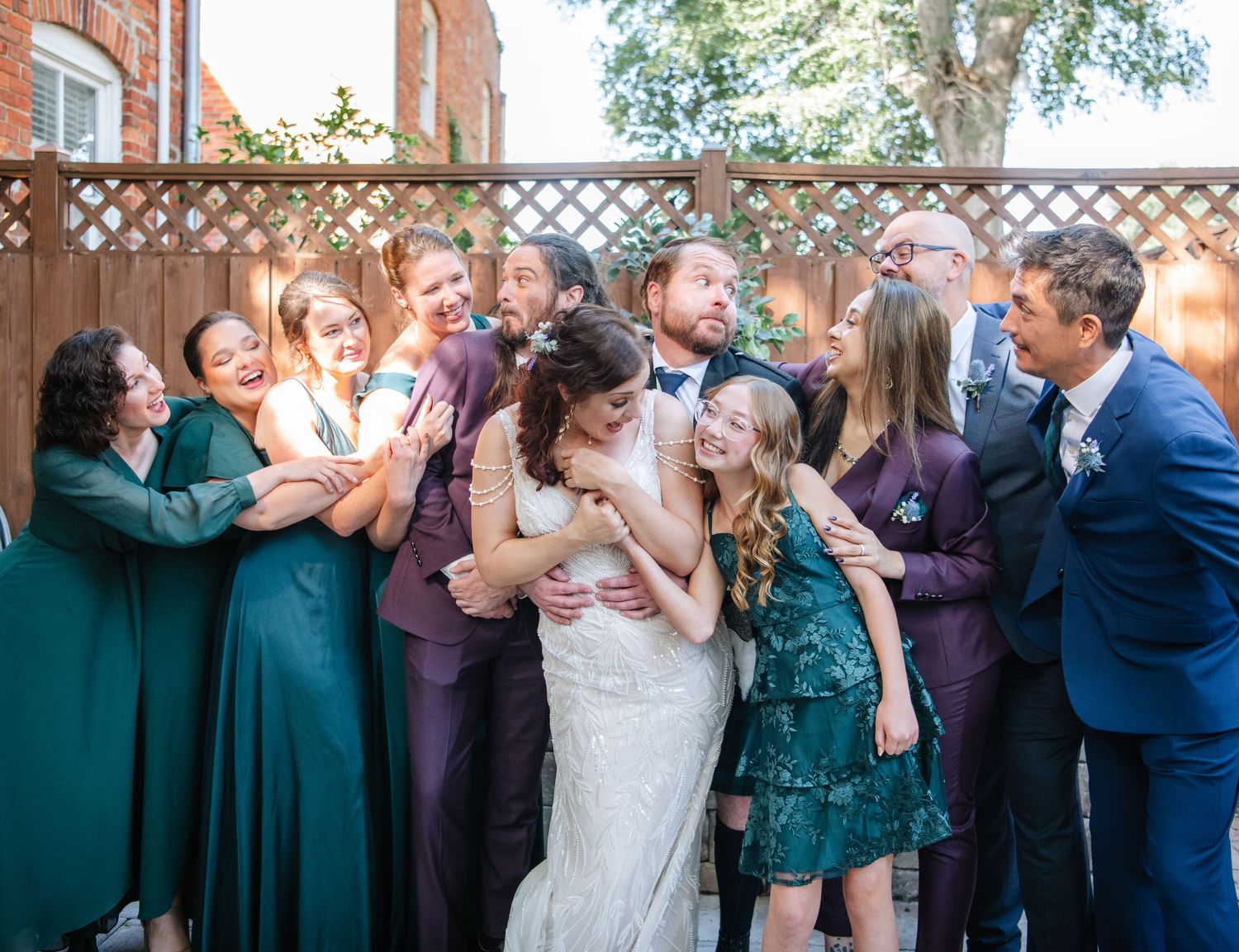Wedding party members dance and celebrate together during a reception in joyful candid moments.