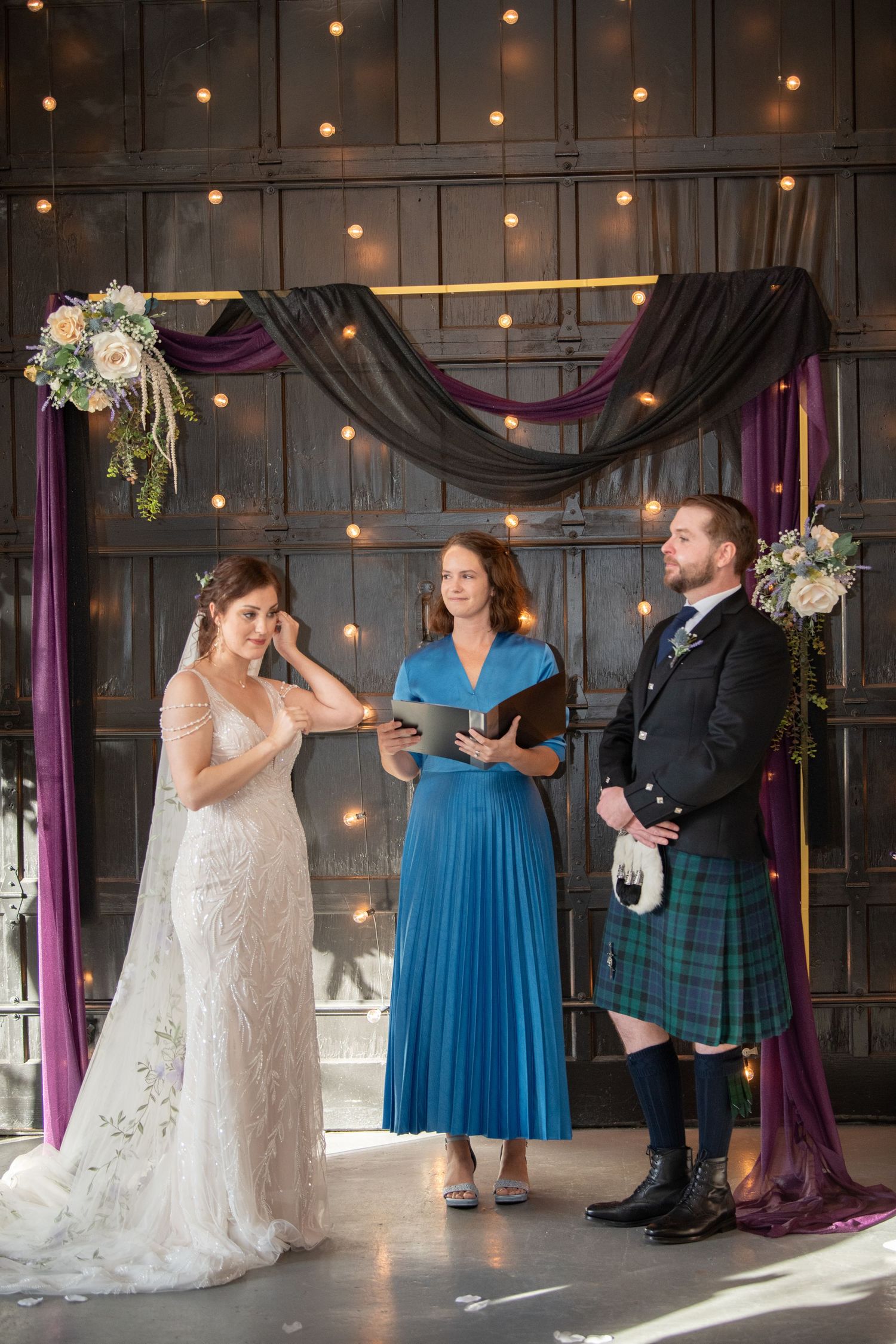 Wedding celebration featuring Scottish attire and elegant decor with string lights and purple accents.