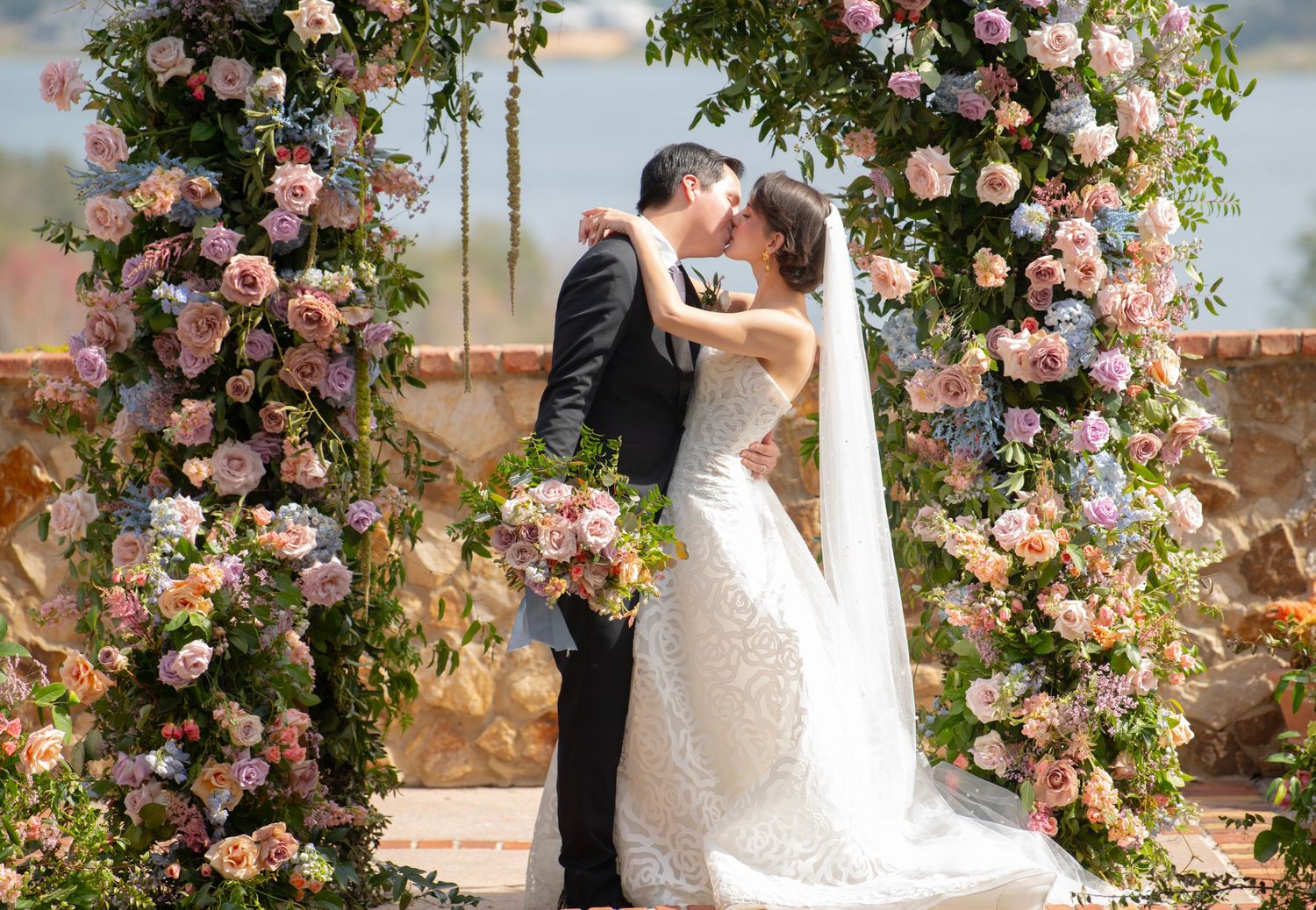 Wedding ceremony site decorated with lush pink floral arrangements and greenery.
