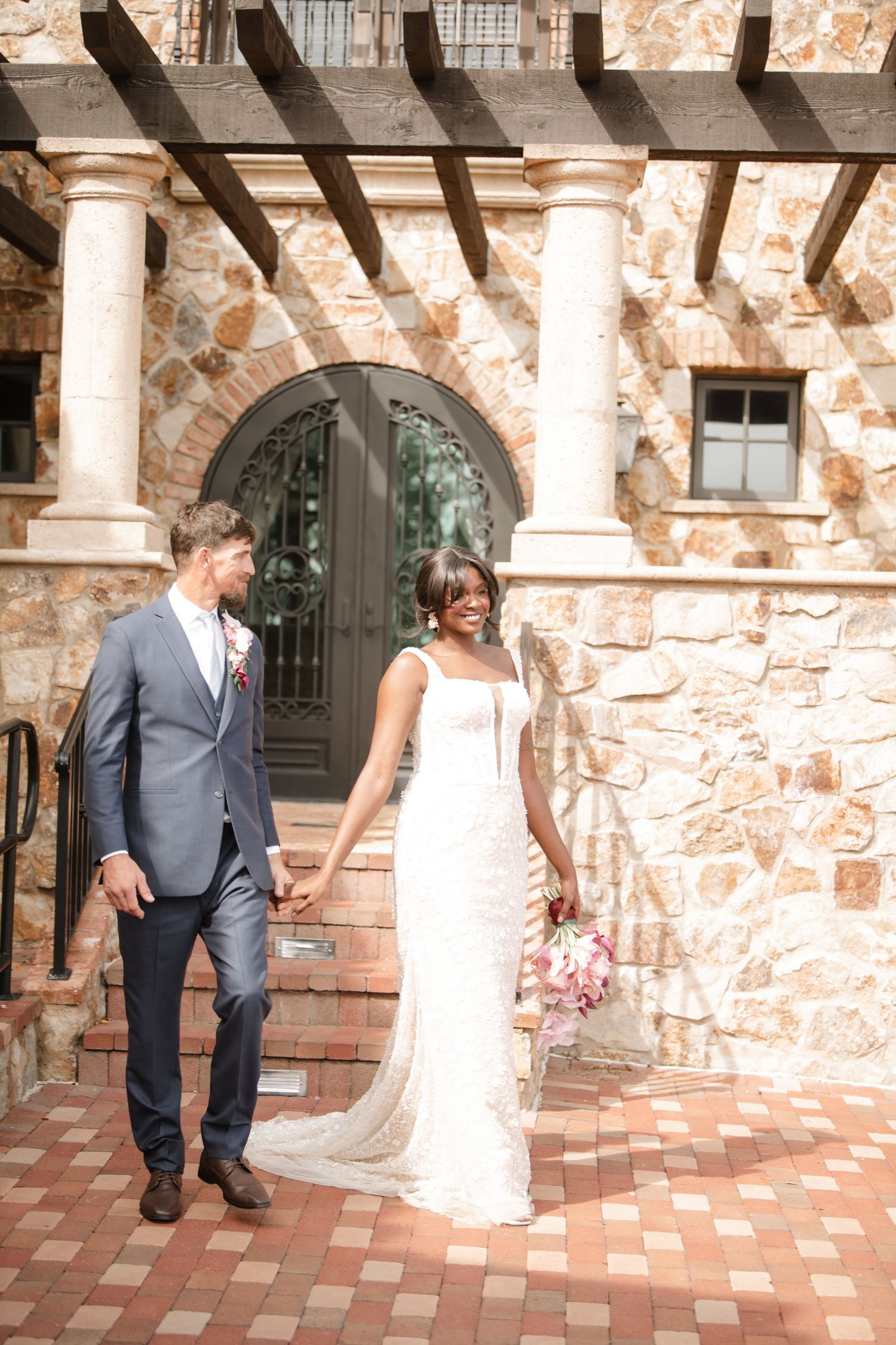 Joyful wedding first look sequence captured in a stone courtyard with terracotta floors.