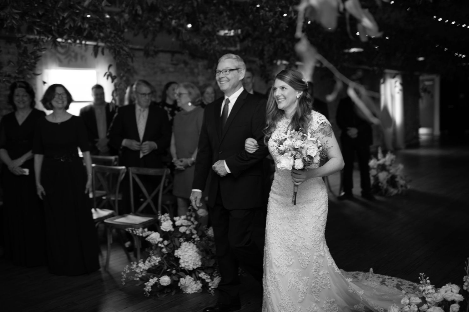Elegant wedding ceremony setup in a rustic brick venue with romantic lighting and floral arrangements.