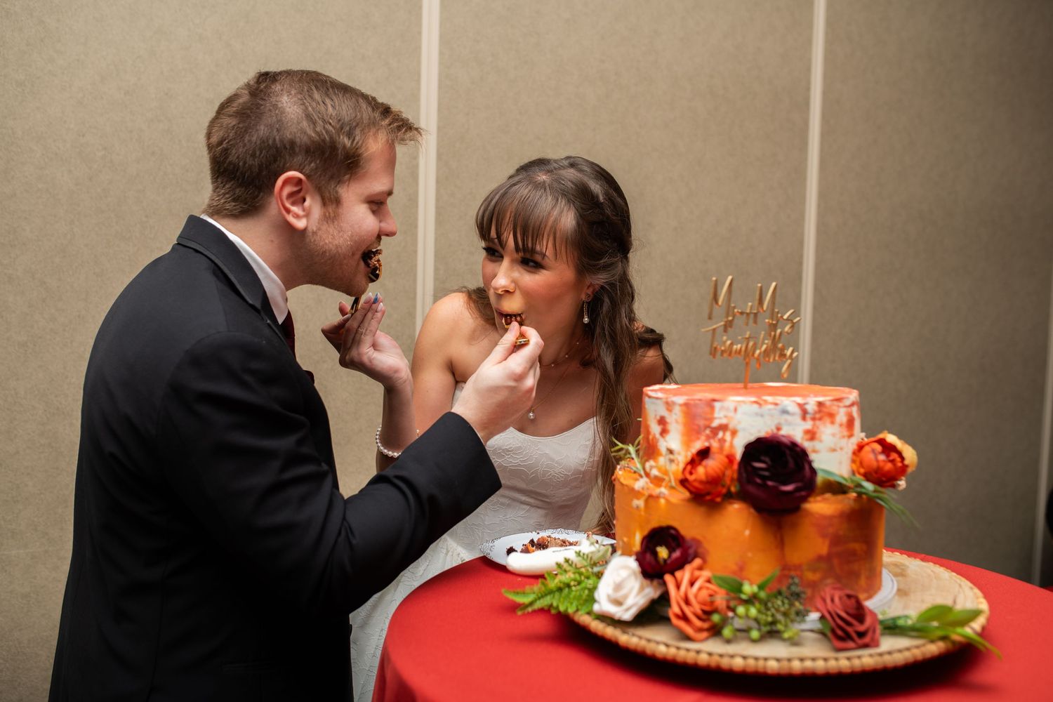 Newlyweds share their first bite of wedding cake at their reception.