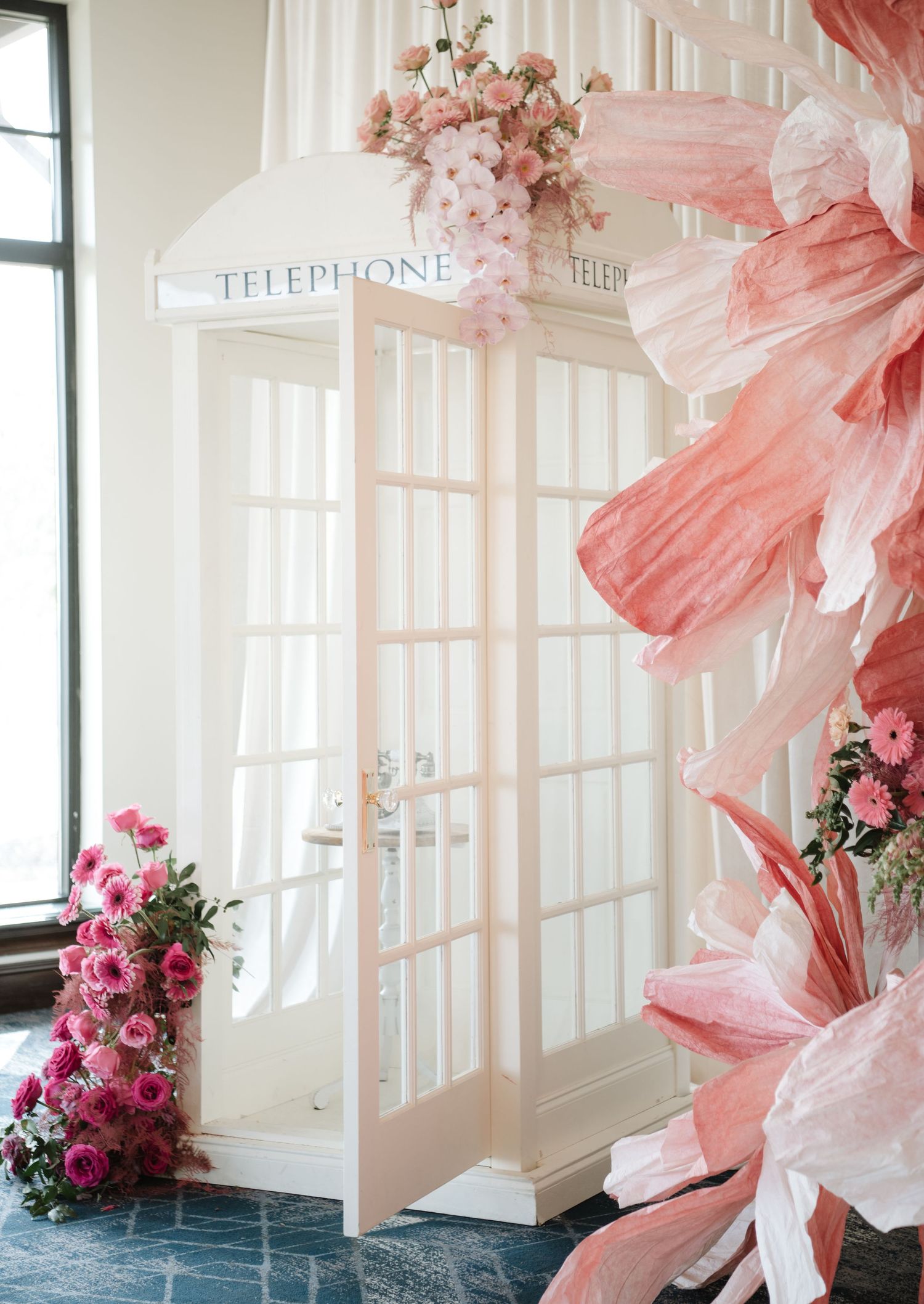 Vintage-style pink and white wedding venue decor with flowing fabric and floral arrangements.