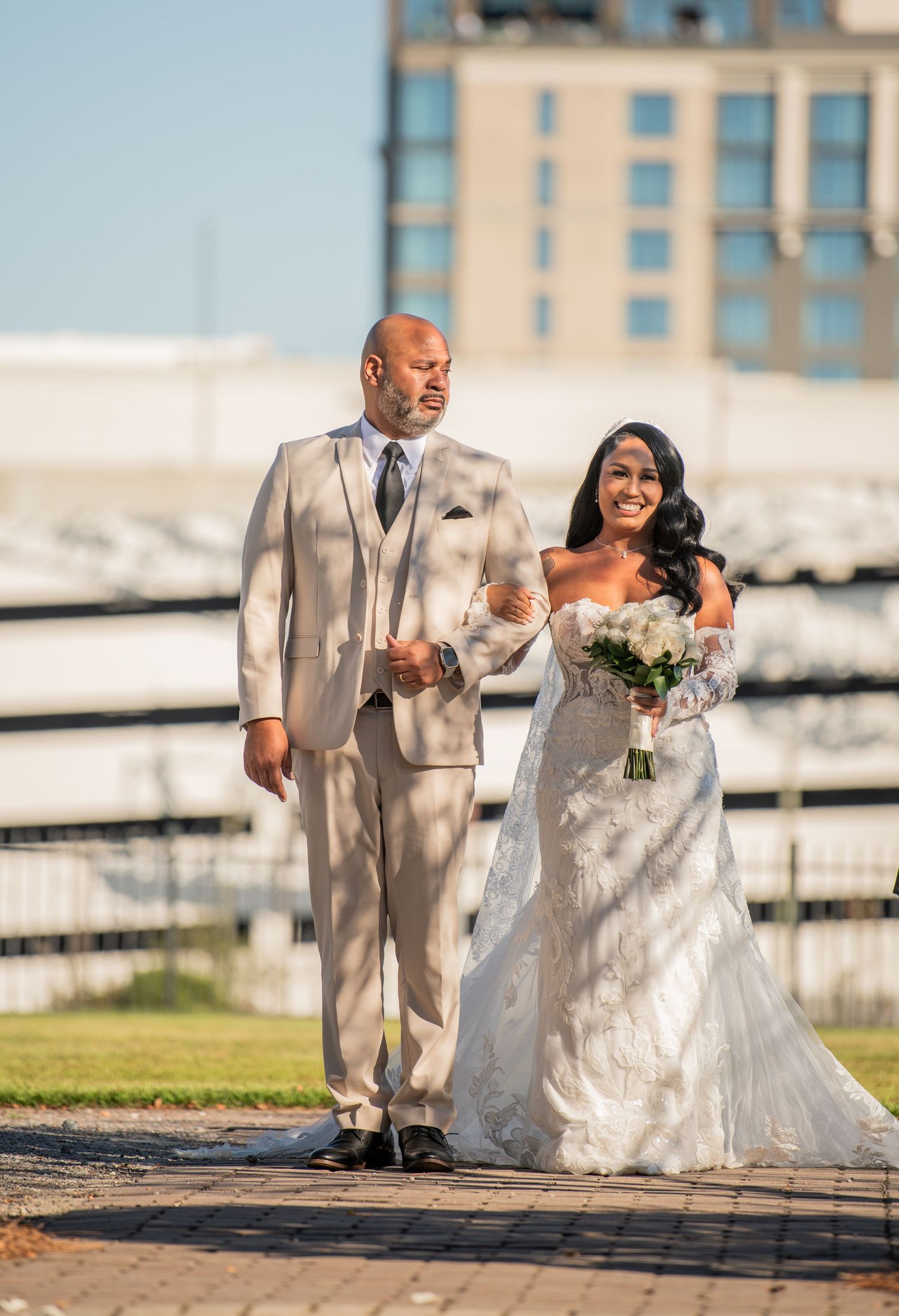 A couple walks together during their wedding ceremony on a brick pathway.