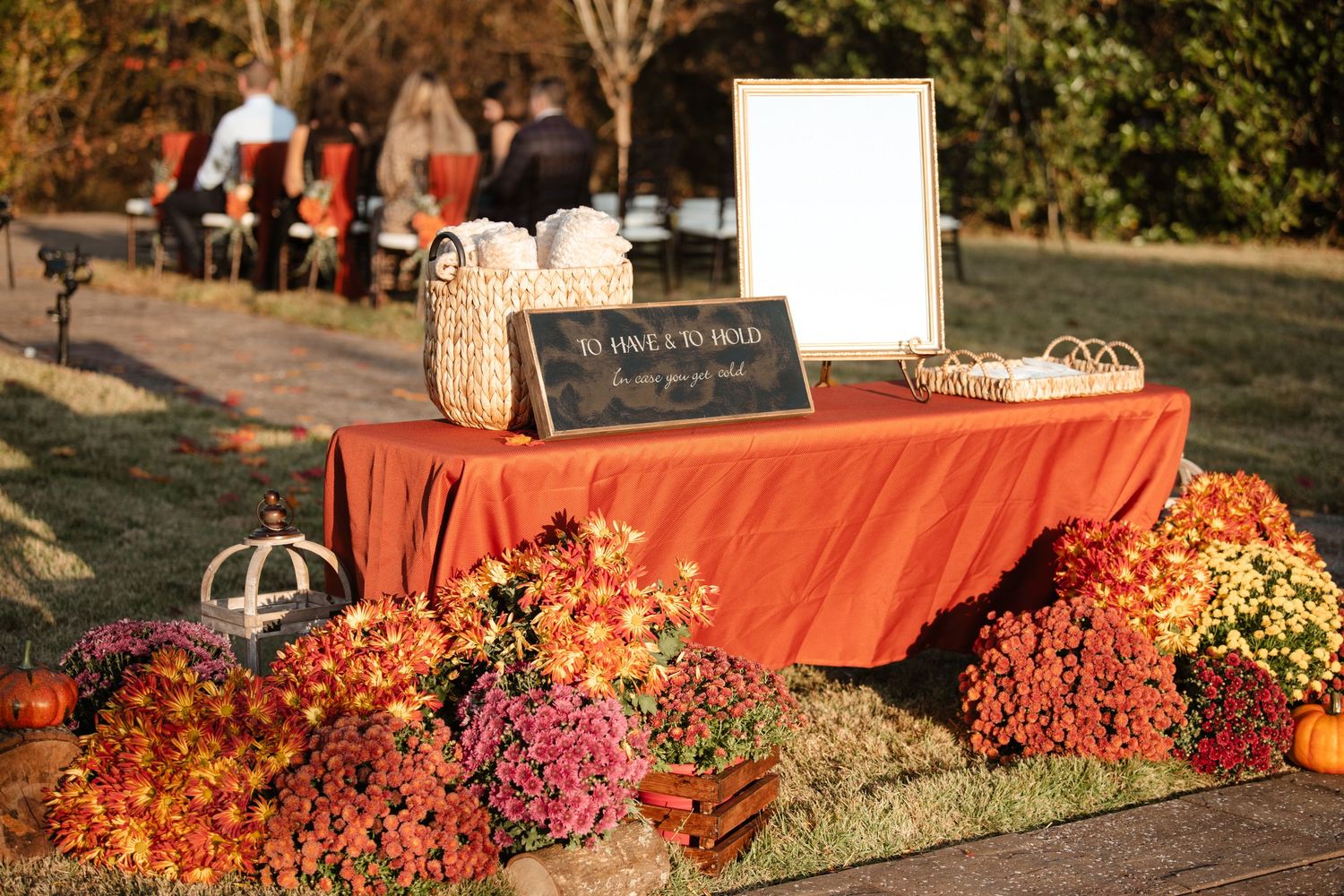 Autumn wedding decor featuring coral-colored accents and natural fall foliage.