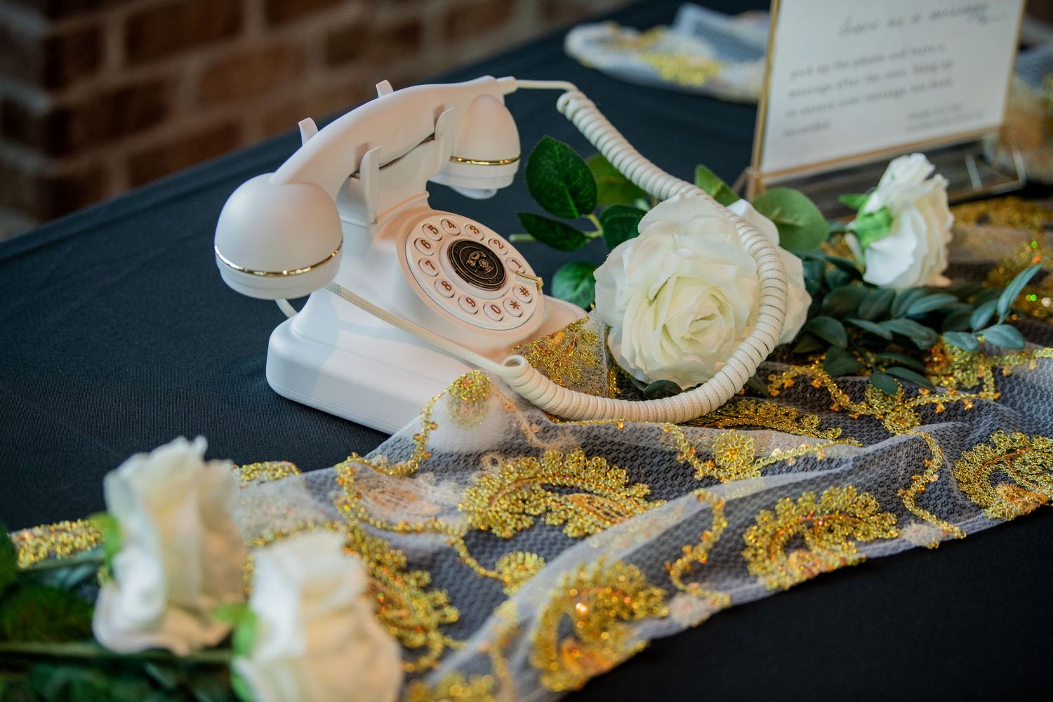 Pink ballet slippers and white roses arranged with golden glitter on a dark surface.