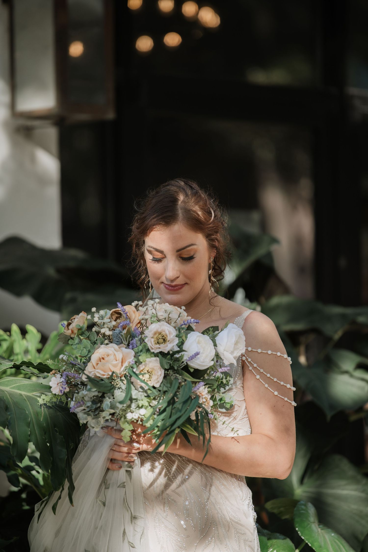 Close-up shots of a bride holding a romantic bouquet with white flowers and greenery.