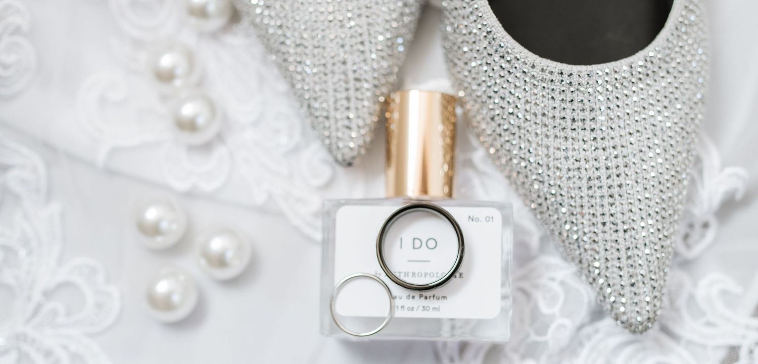 Wedding accessories including pearls, crystals and delicate jewelry on light background.