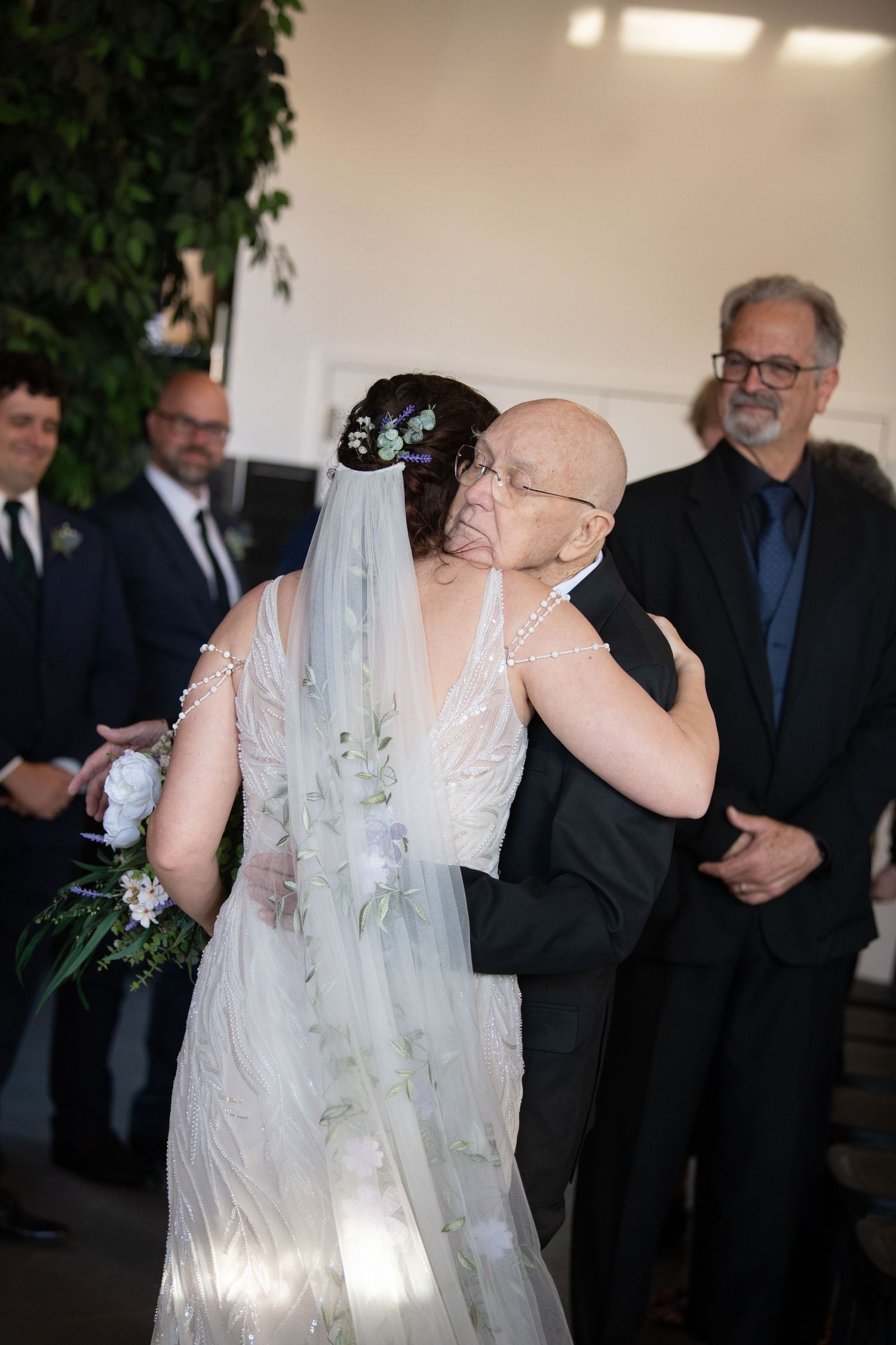 Wedding ceremony with guests in formal attire watching a special moment unfold.