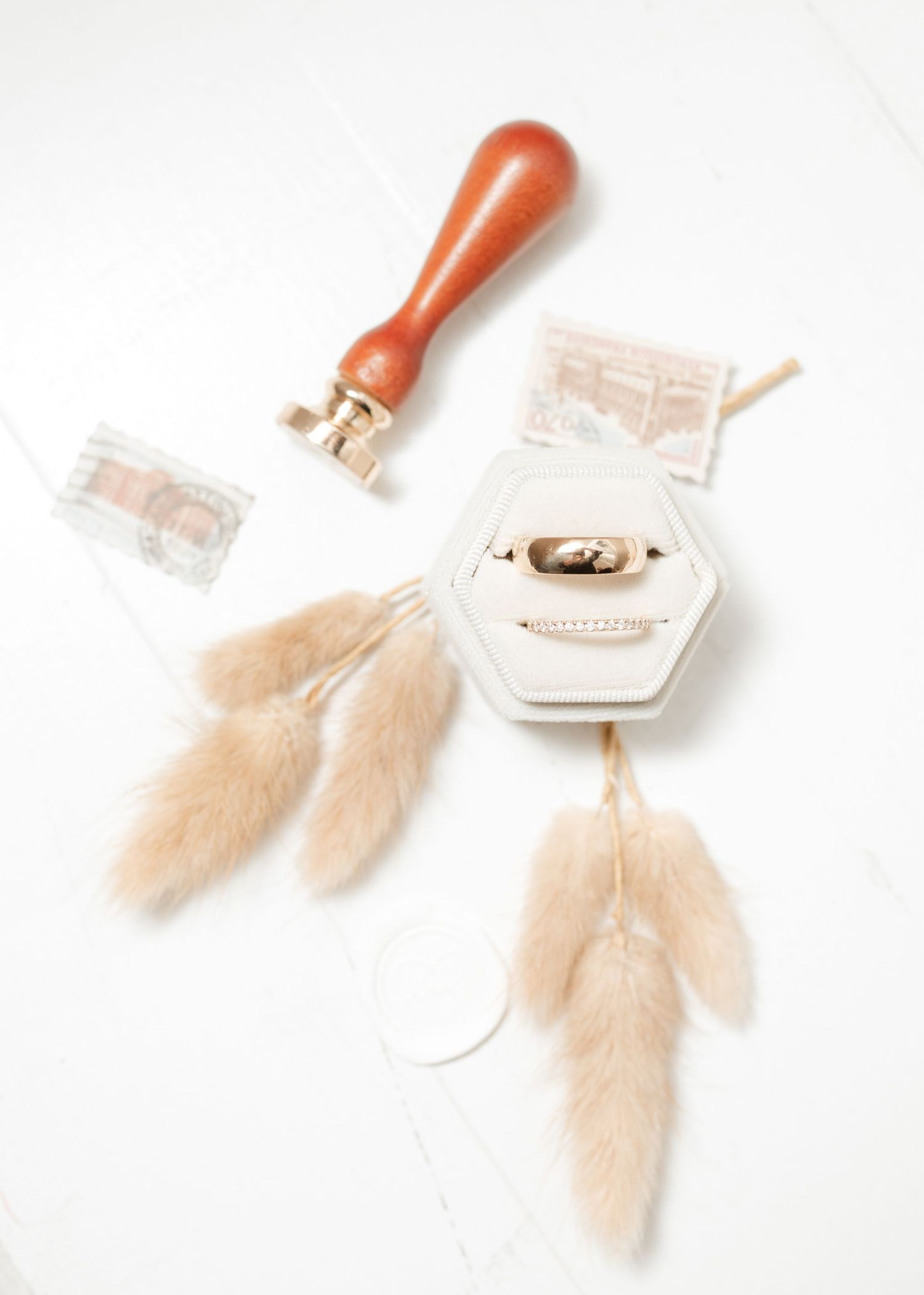 Vintage-style wax seal stamps with delicate feathers in soft beige tones on white background.