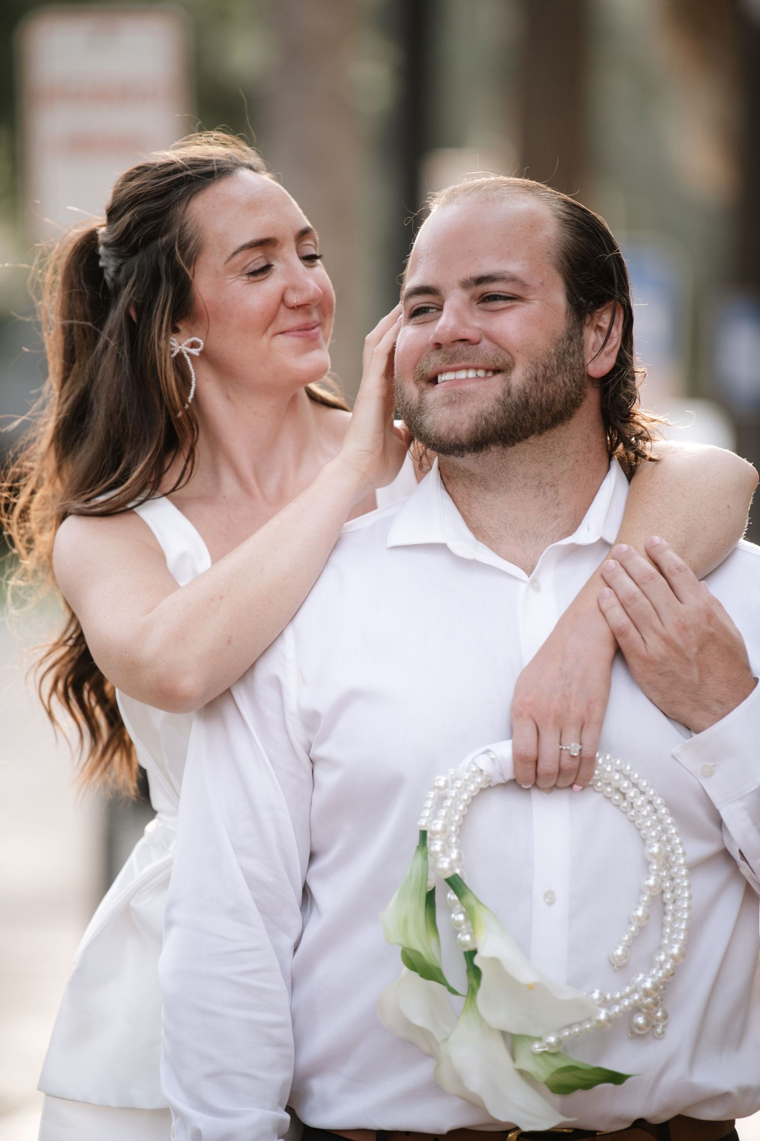 A romantic couple in white outfits shares intimate moments in a series of candid photos showing their affection.