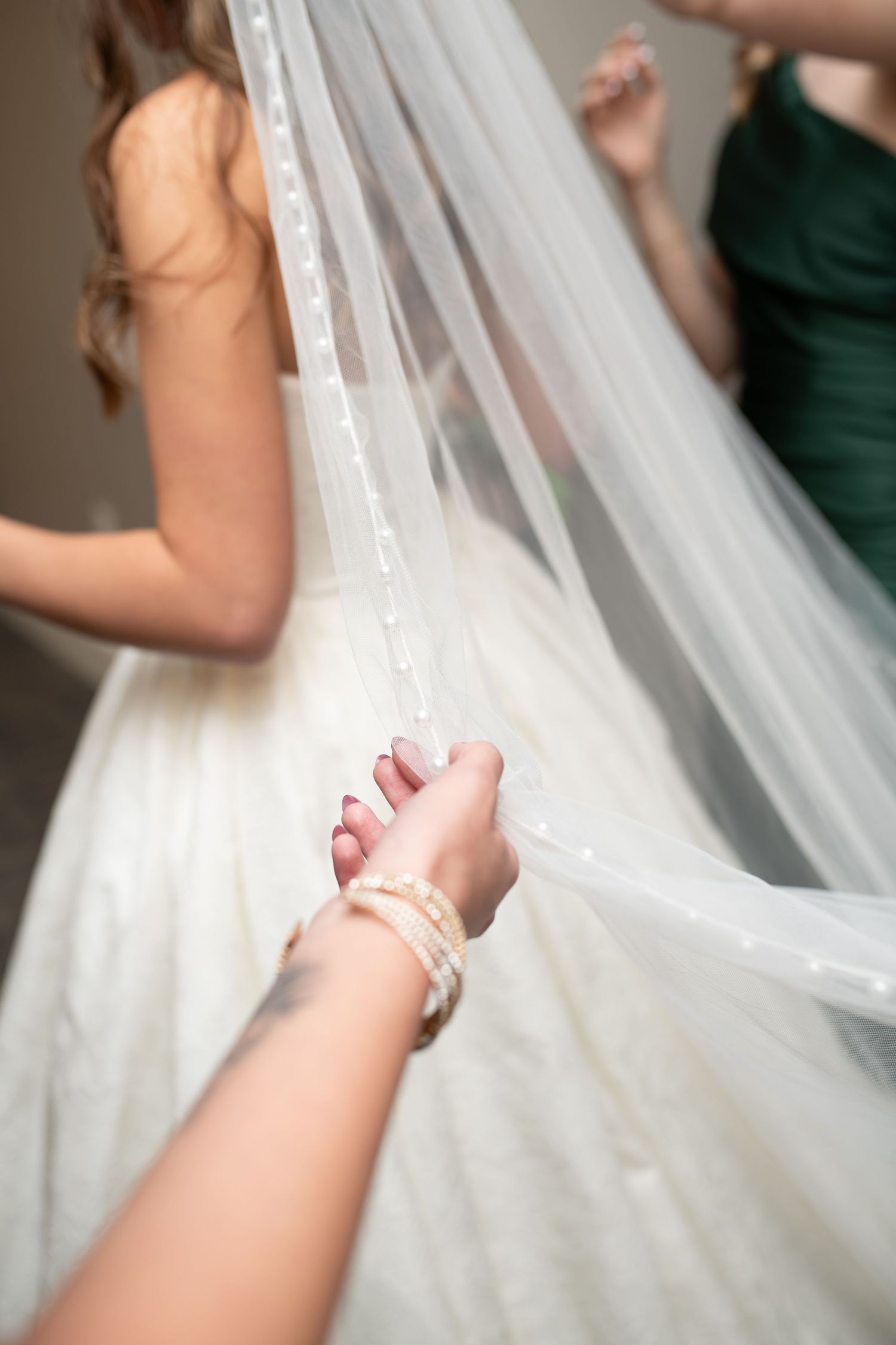 Delicate white wedding veil being adjusted in a series of close-up shots.