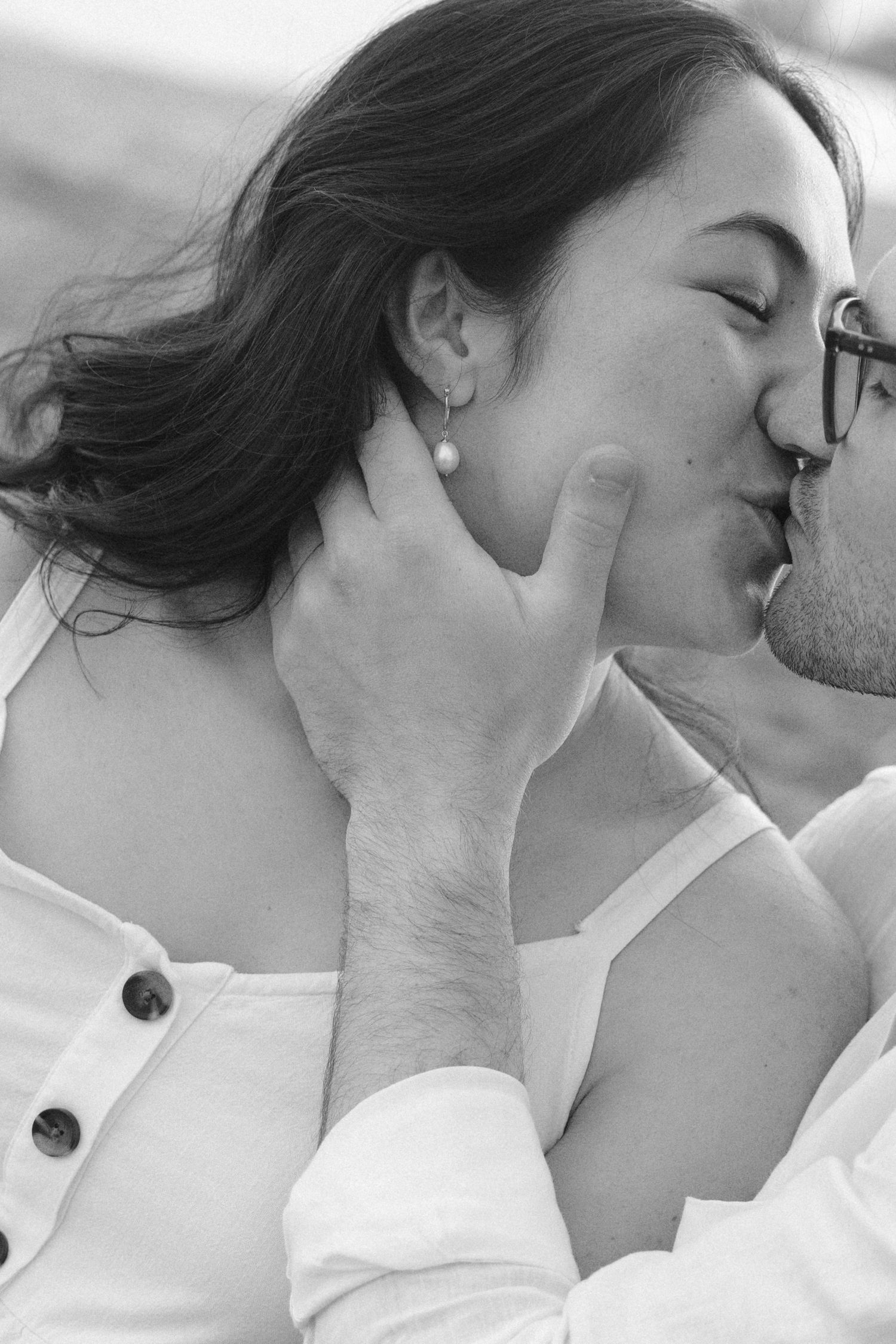 Romantic black and white close-up of a couple sharing a tender kiss during an engagement session.