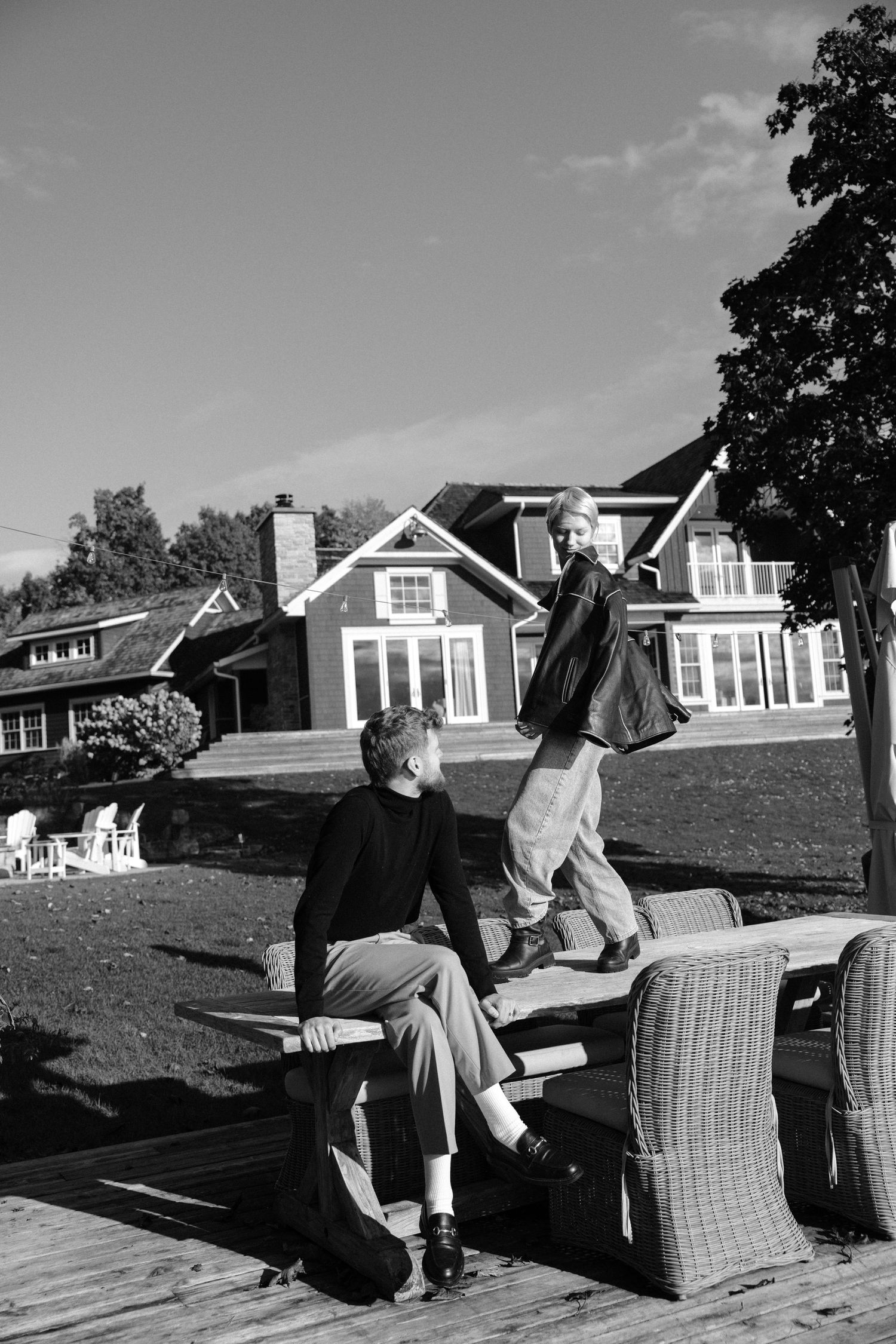Black and white couple on outdoor deck of large country estate home.