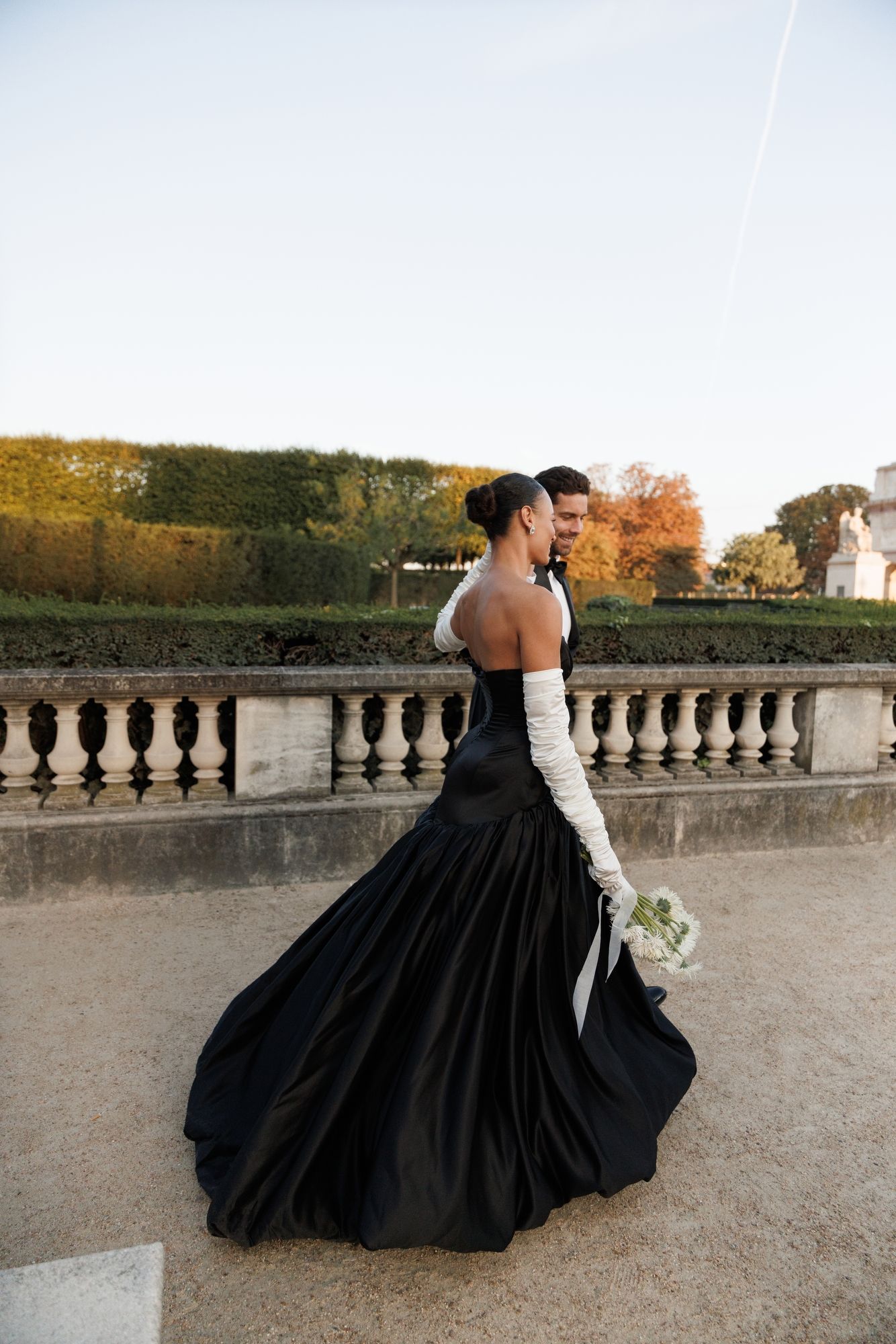 Dramatic wedding photos with flowing black ballgown dress in autumn garden setting. Paris Louvre