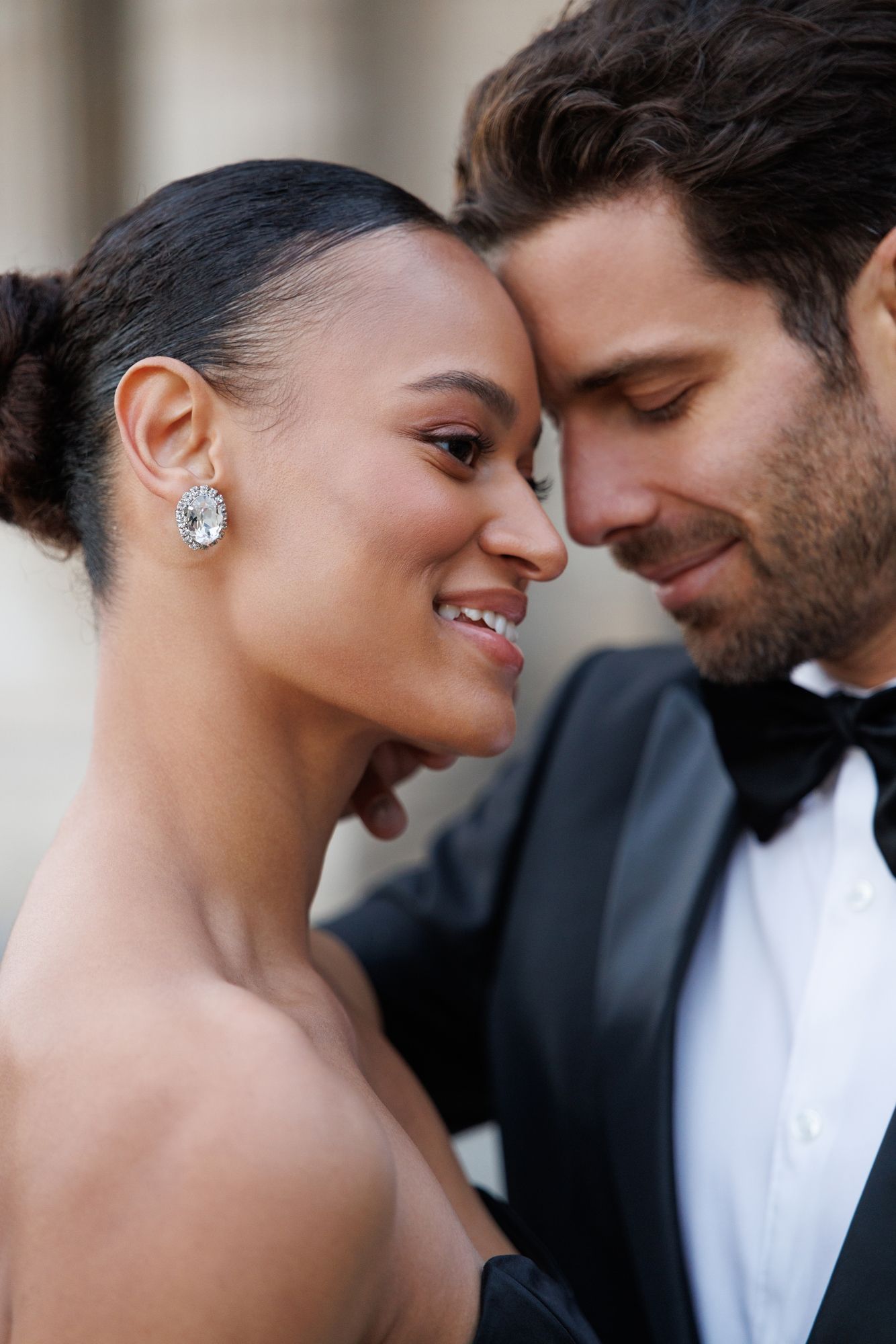 Romantic couple shares intimate close-up moments in formal attire against dark background. Paris Louvre