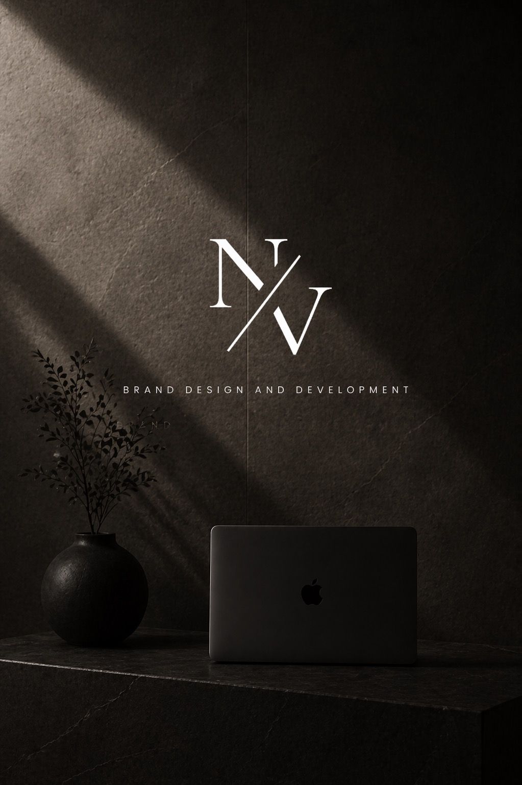 Elegant dark brand design studio logo NV on textured wall with laptop and black vase, minimalist aesthetic.
