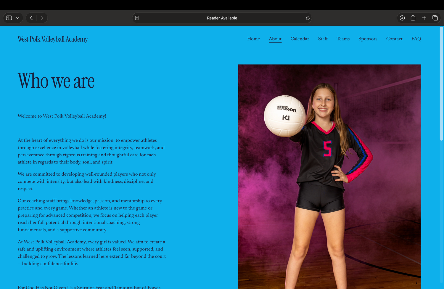 A young female volleyball player in a black and blue uniform holds a ball, posing confidently in a dramatic smoky background.