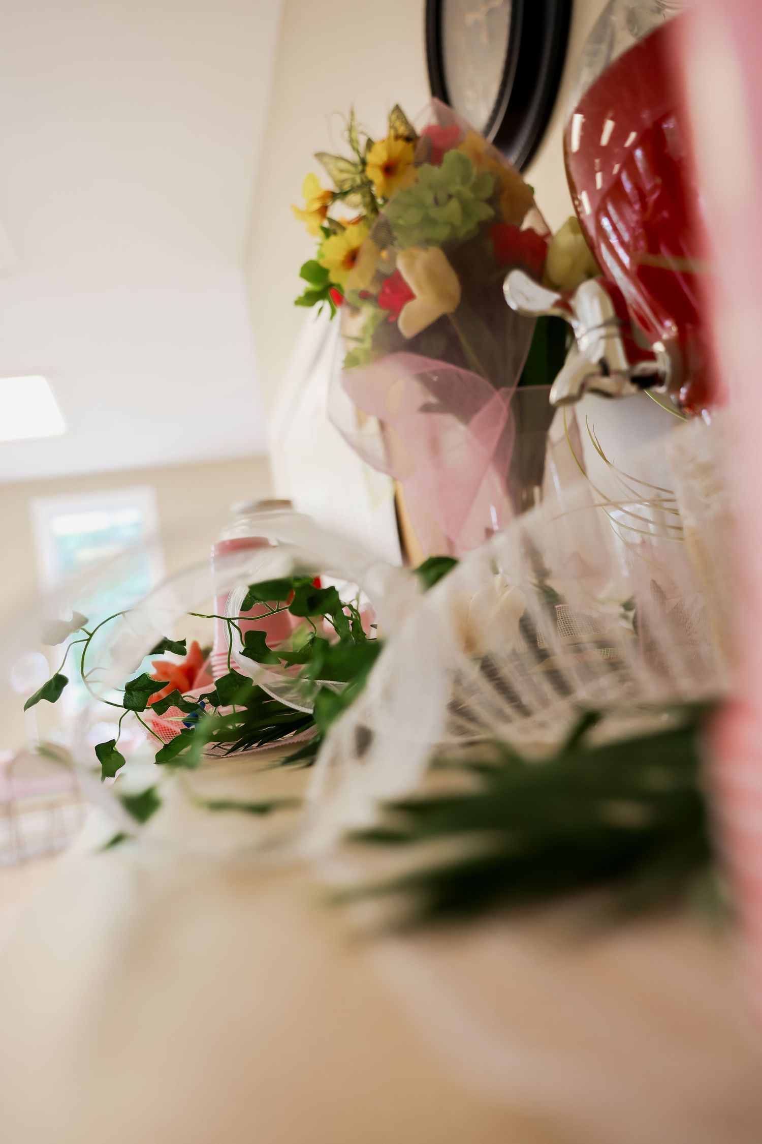 Elegant floral arrangement with colorful flowers in a vase and a glass bowl with pink blooms on a white table.