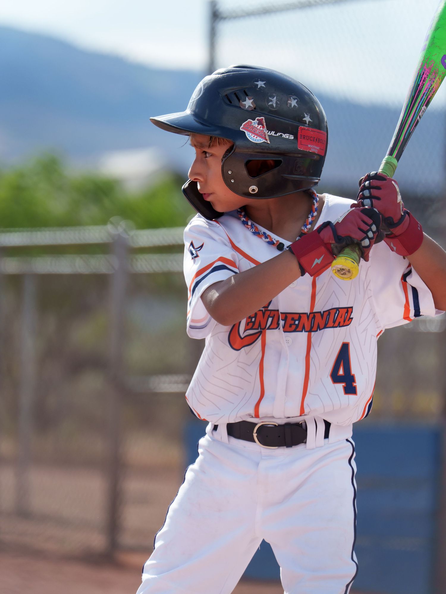 Youth baseball player number 4 in batting stance wearing helmet ready to hit during a little league game.