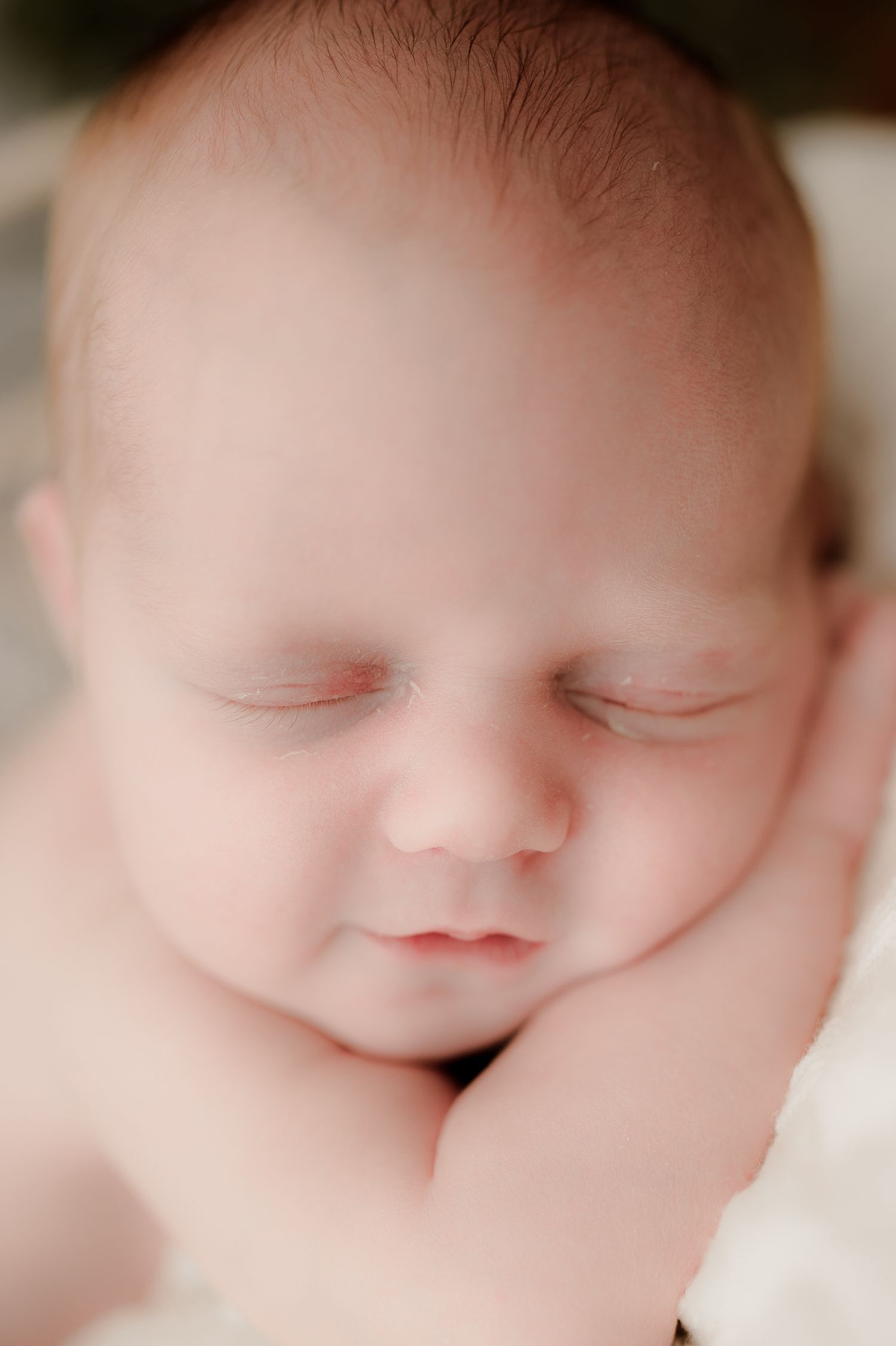 Soft close-up portrait of peaceful sleeping newborn baby face.