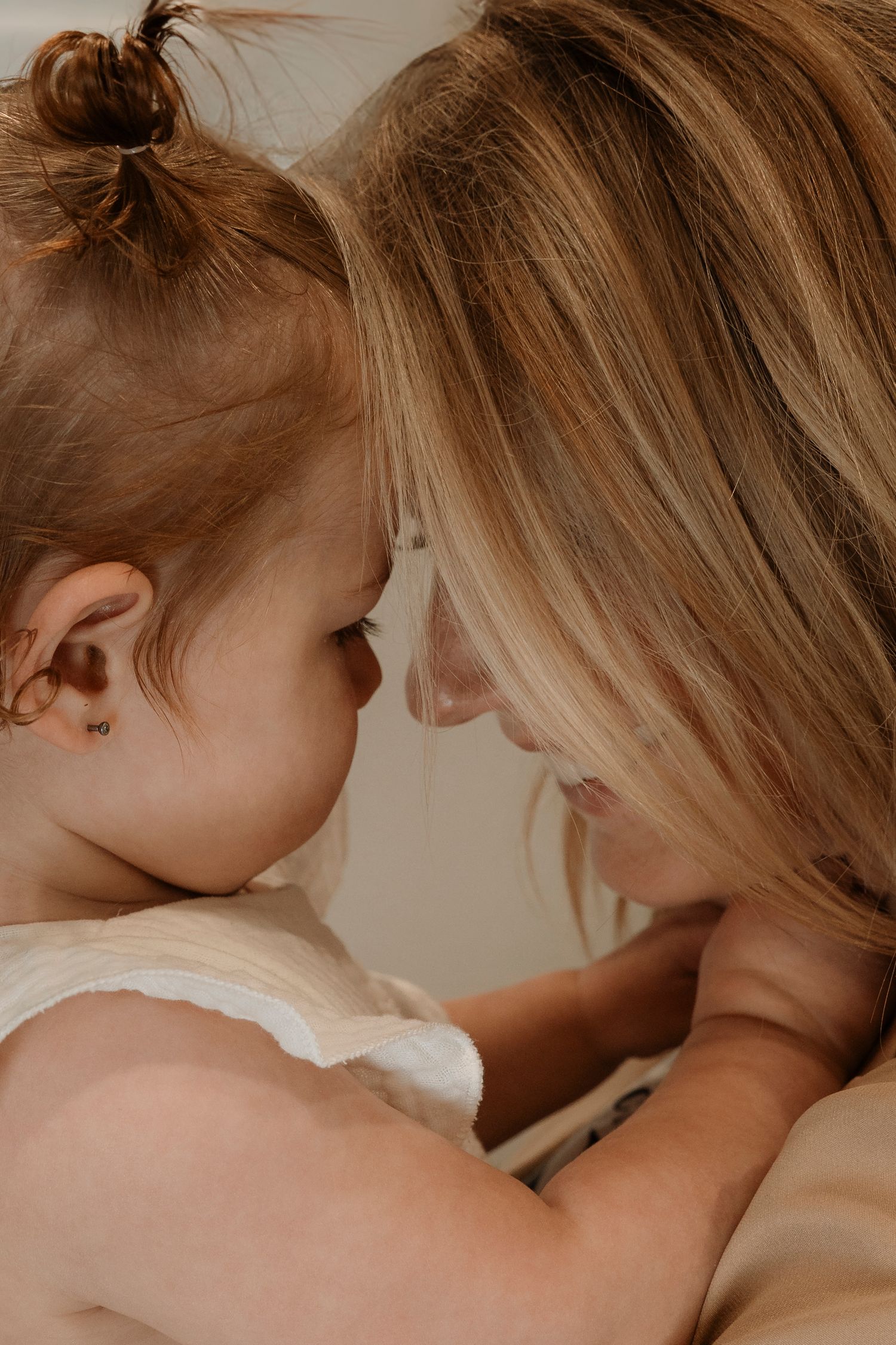 Close-up of a mother and toddler daughter touching foreheads in a tender moment.Family photography in Regina Saskatchewan.