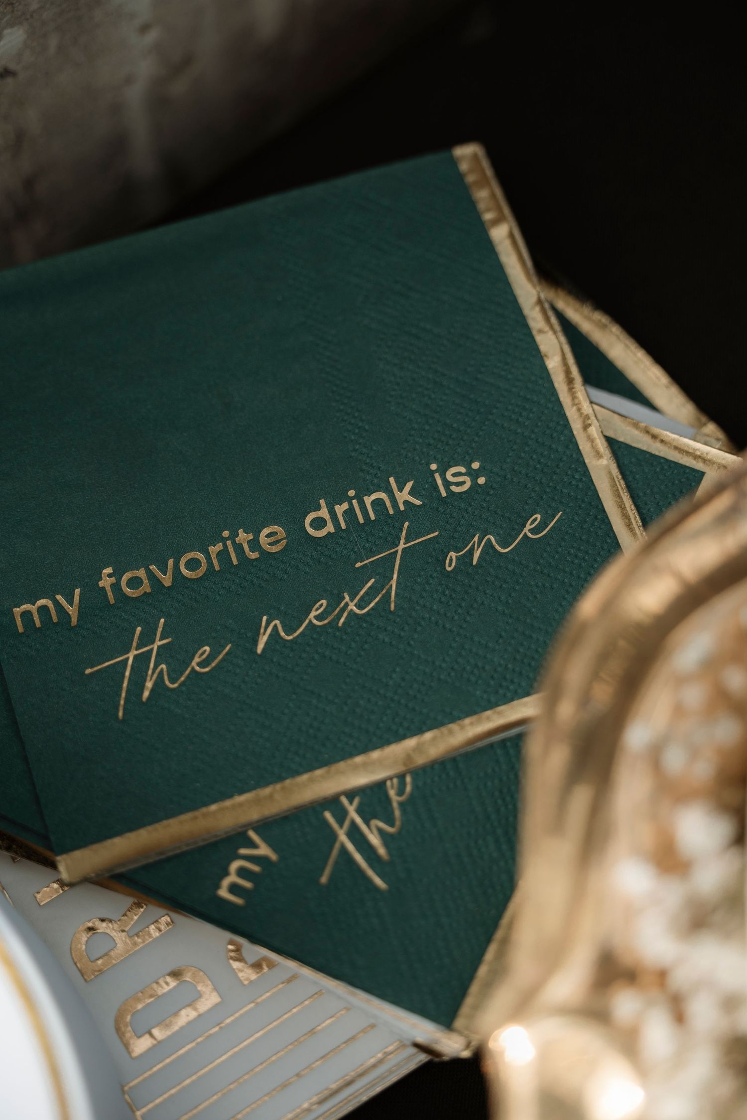 Green and gold cocktail napkins reading 