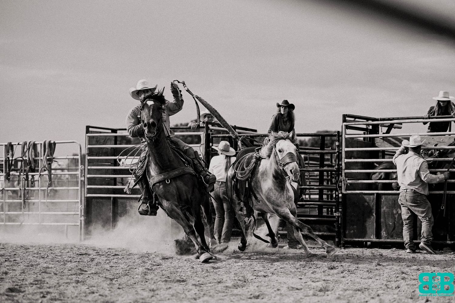 Cowboys demonstrating skilled horsemanship during a rodeo competition.