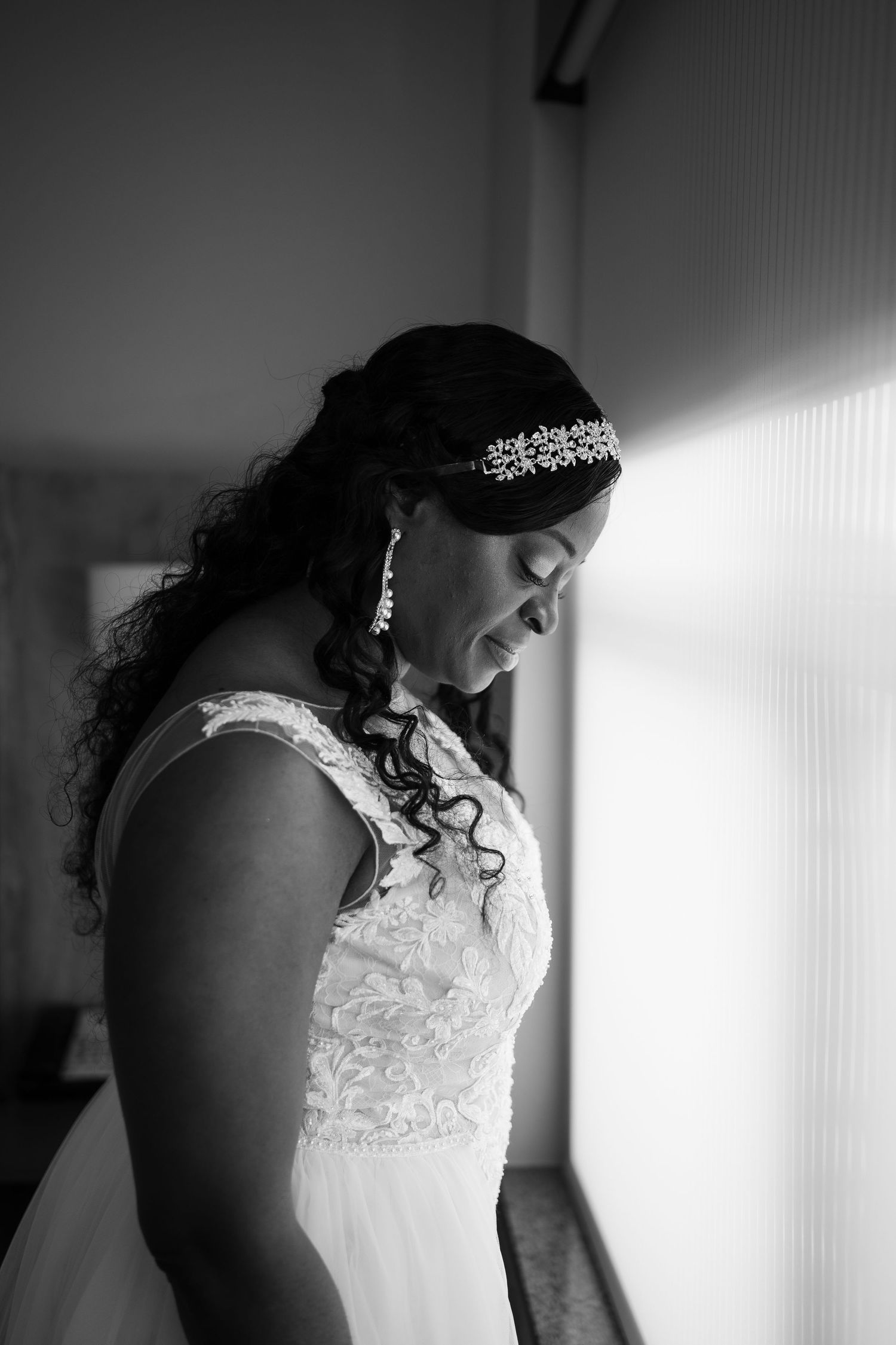 Artistic black and white bridal portrait showing lace dress details and tiara.