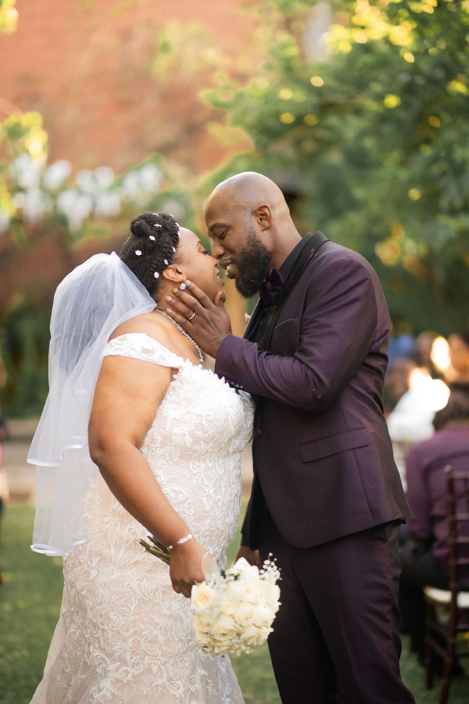 A tender moment between newlyweds during their outdoor garden wedding ceremony.