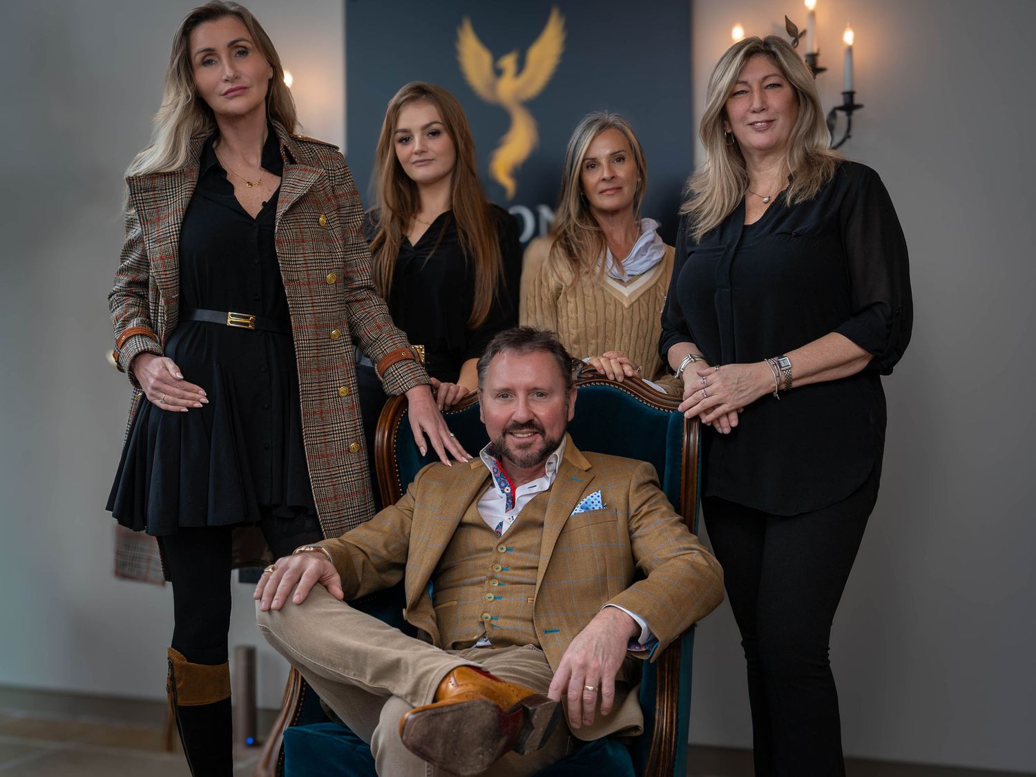A group of people pose together in a studio setting wearing casual business attire in a series of connected photos.