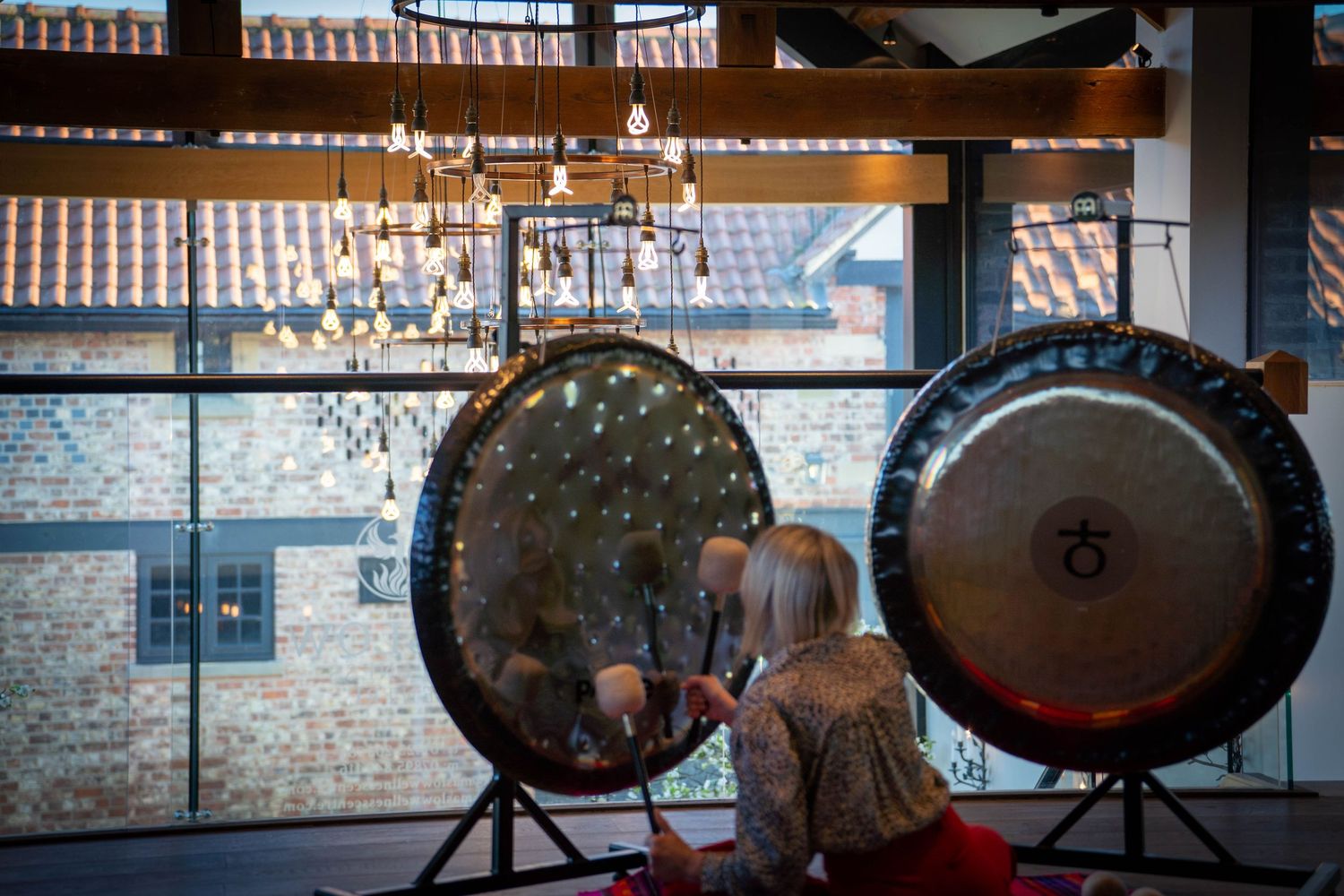 Drum cymbals and percussion equipment arranged on stage with stage lighting visible in the background.
