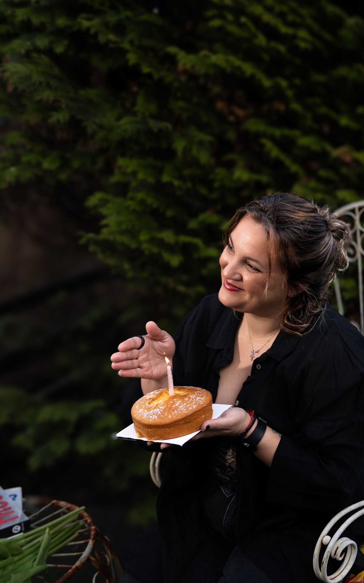 A person enjoying a donut outdoors with a playful expression against a dark green background.
