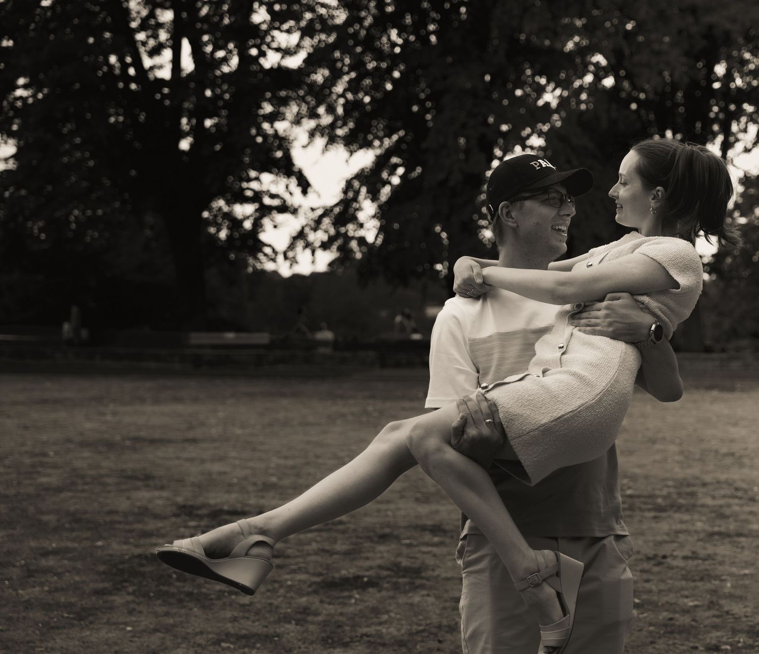 A playful couple's photoshoot sequence in black and white outdoors.
