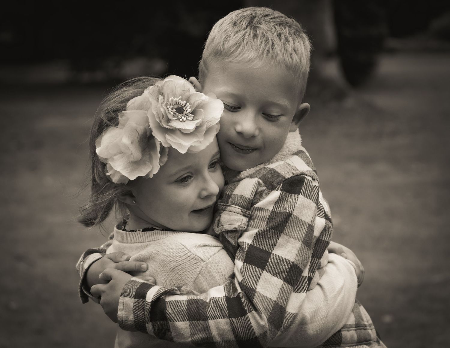 Sweet black and white portrait series showing tender family moments in a natural outdoor setting.