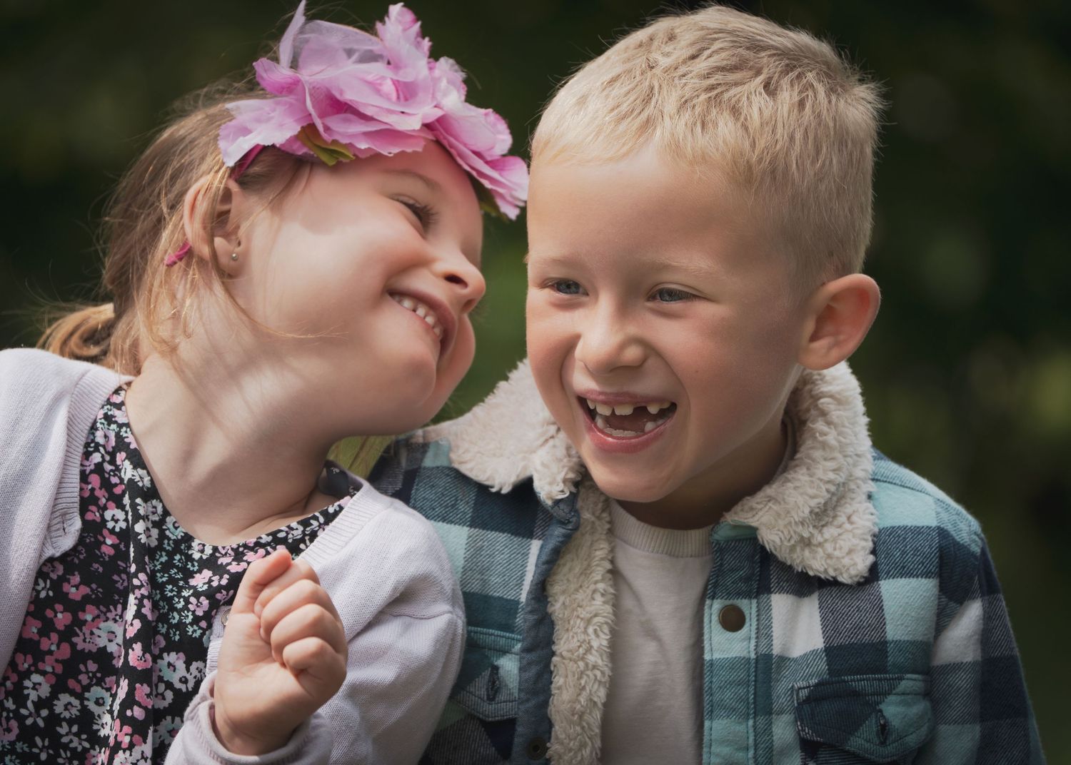 Two children sharing playful moments with pink hair accessories.