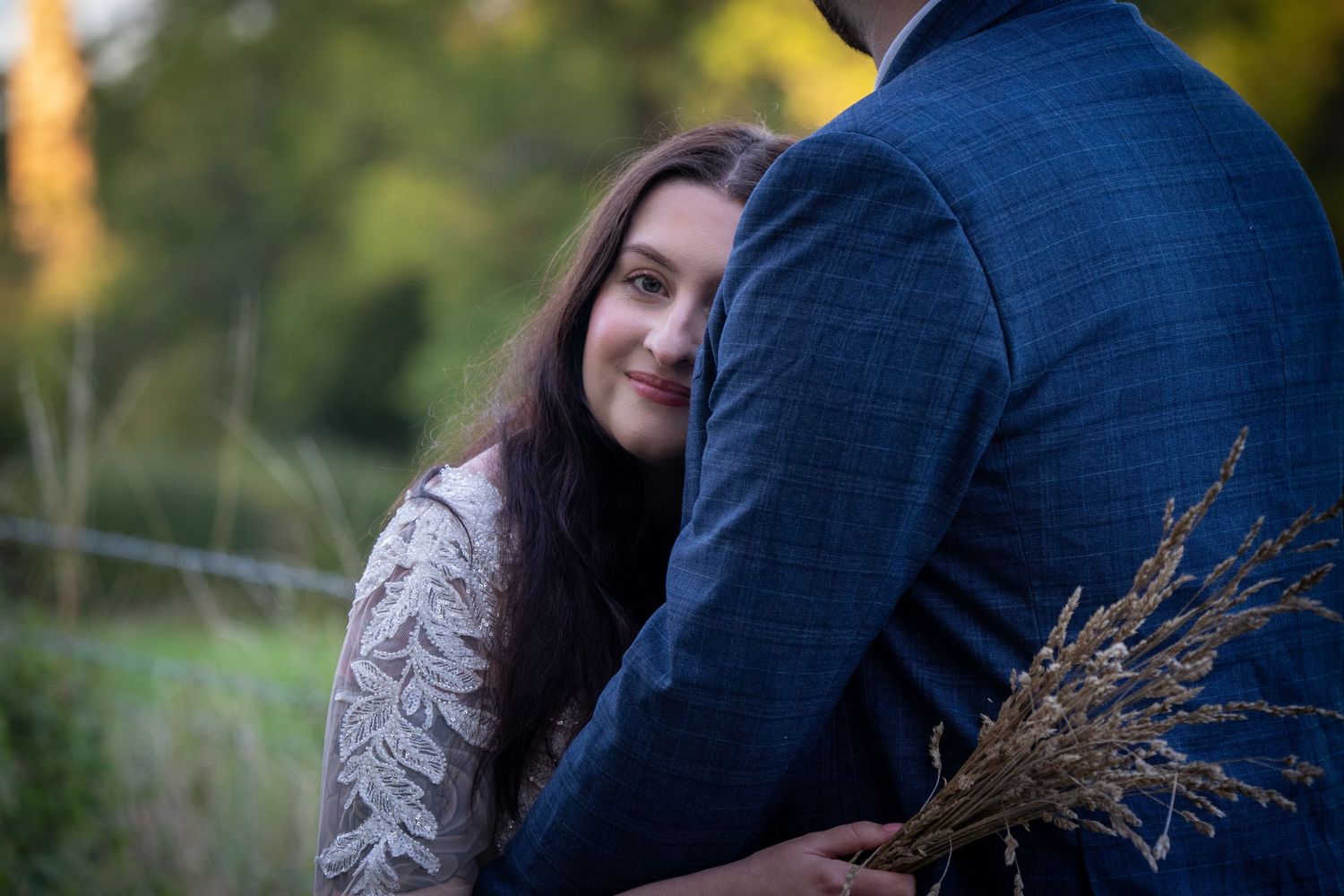 A romantic outdoor photoshoot with autumn foliage in the background.