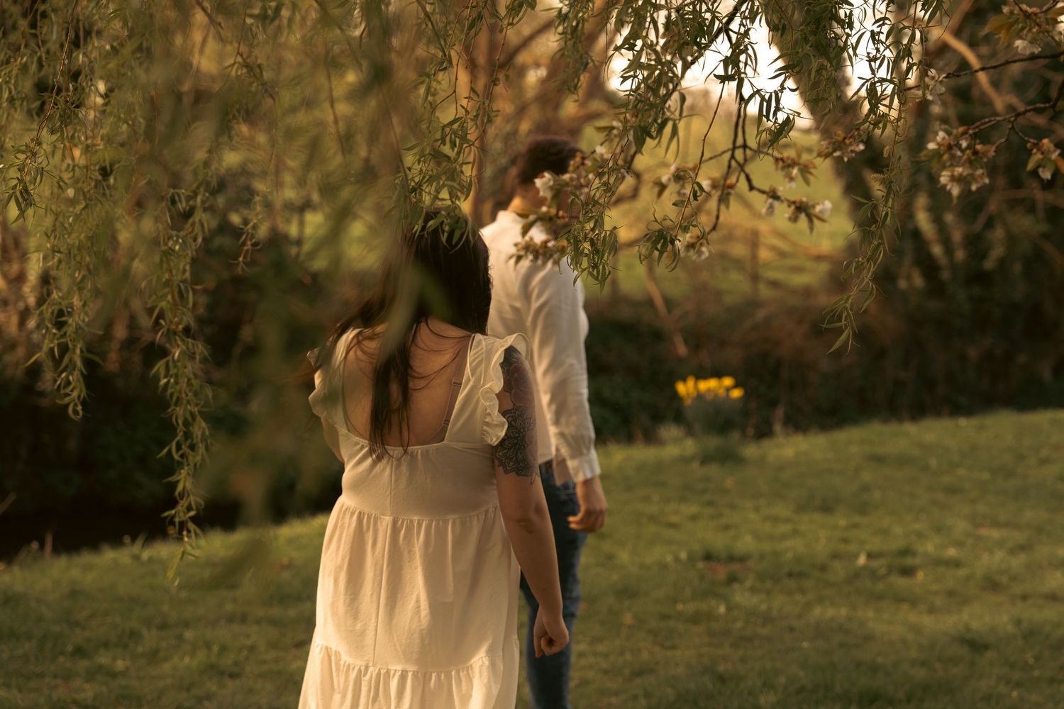 A romantic outdoor photoshoot in warm evening sunlight with natural scenery.