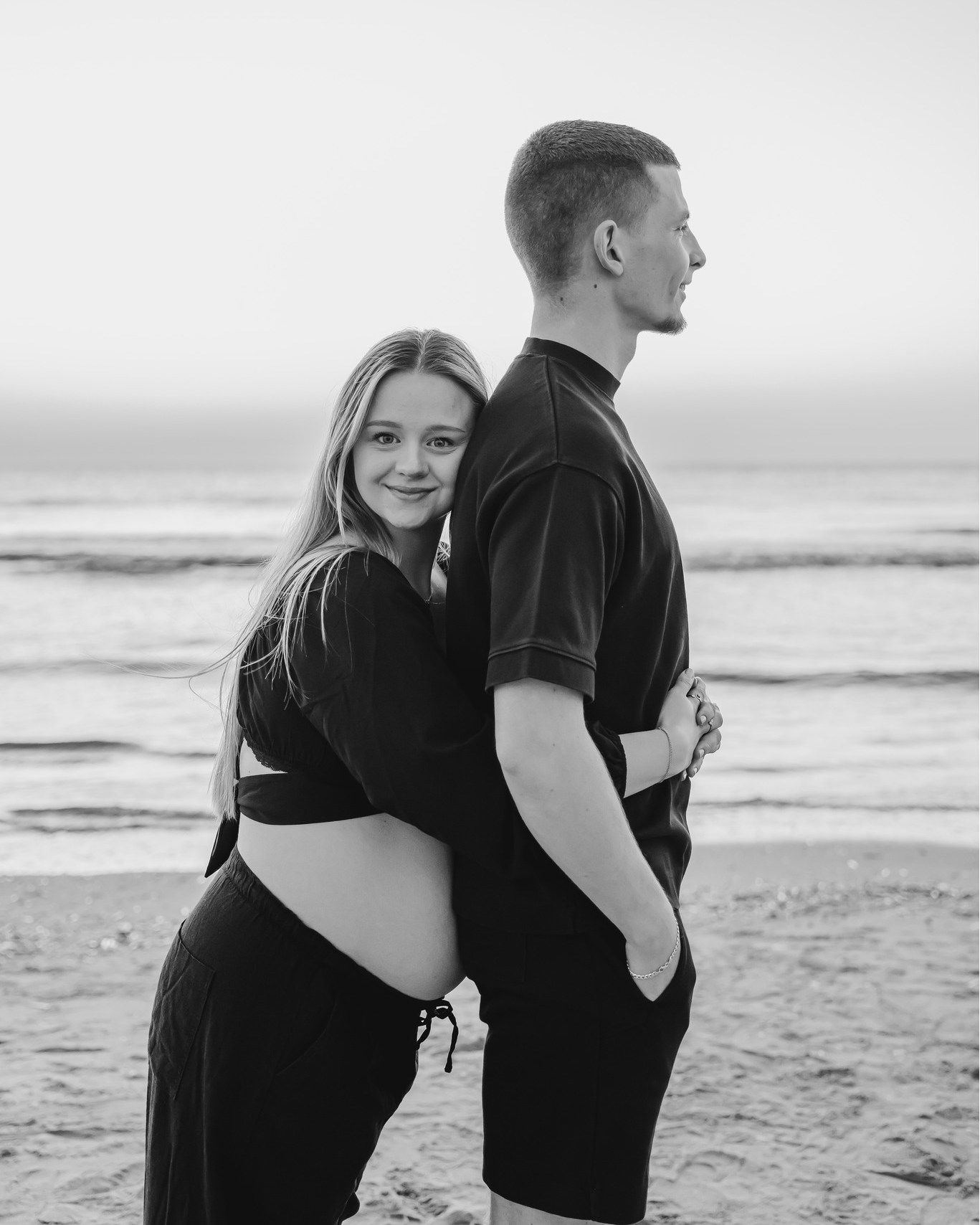 Twee koppels op het strand tijdens een zwangerschap fotoshoot.