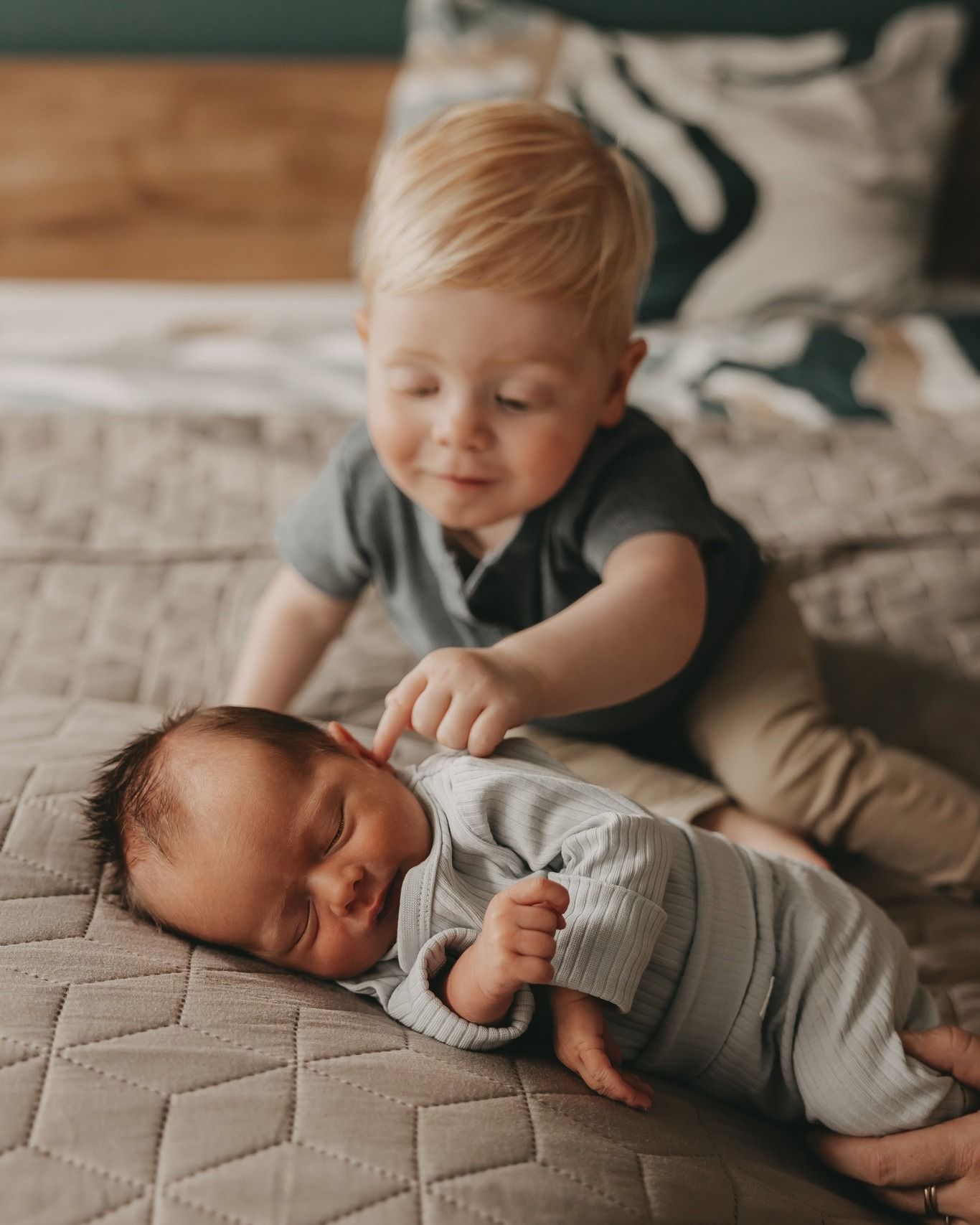 Een kindje die zijn baby newborn broertje bekijkt.