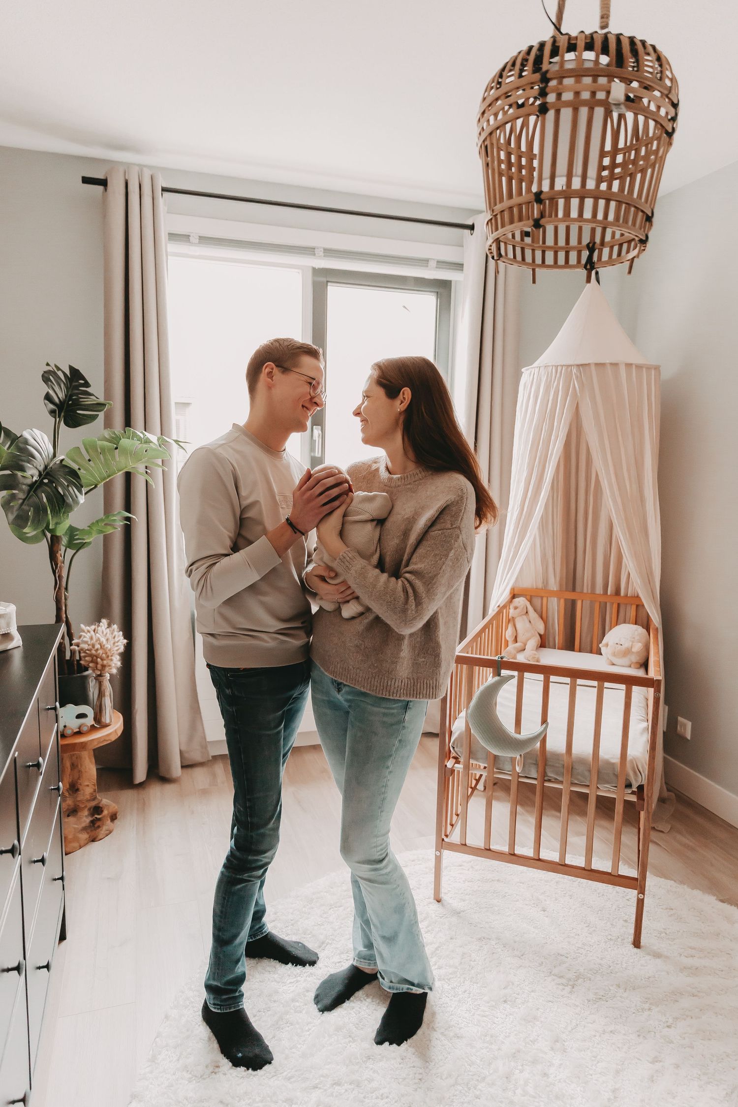 Papa en mama samen in de nieuwe babykamer tijdens een newborn fotoshoot.